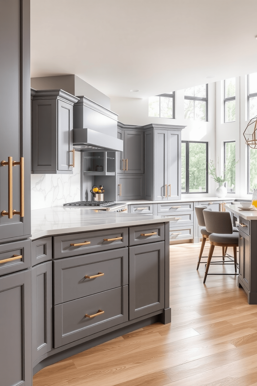 A contemporary kitchen featuring gray cabinets with sleek brass hardware. The space is accented by a white marble backsplash and a large island with bar stools for casual dining. The flooring is a light hardwood, adding warmth to the modern aesthetic. Natural light floods the room through large windows, enhancing the inviting atmosphere.