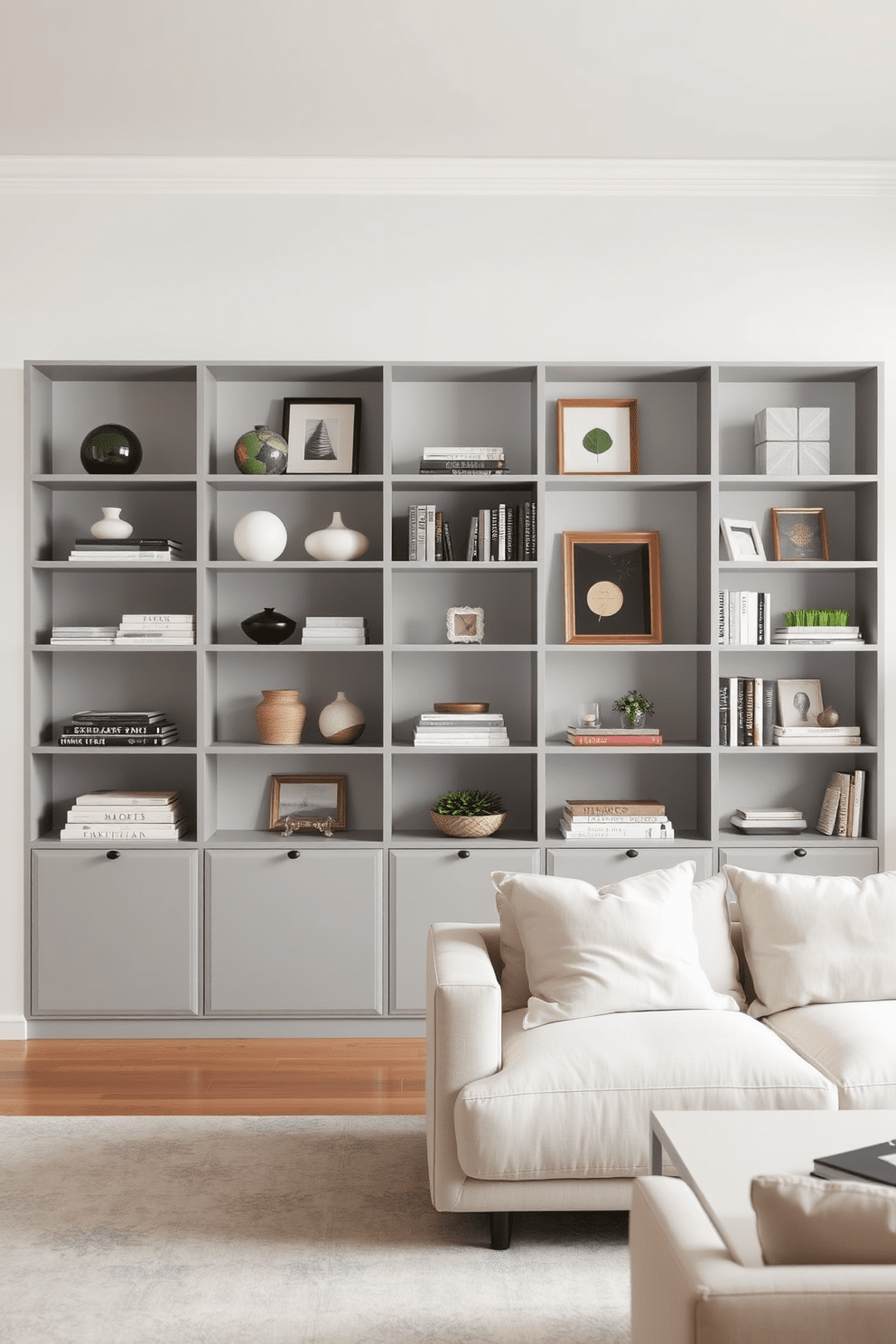 A modern living room featuring open shelving in soft gray tones. The shelves are filled with carefully curated decor items and books, creating a stylish yet functional display. The walls are painted in a complementary light gray, enhancing the overall aesthetic. A cozy seating area includes a plush sofa and a minimalist coffee table, inviting relaxation and conversation.