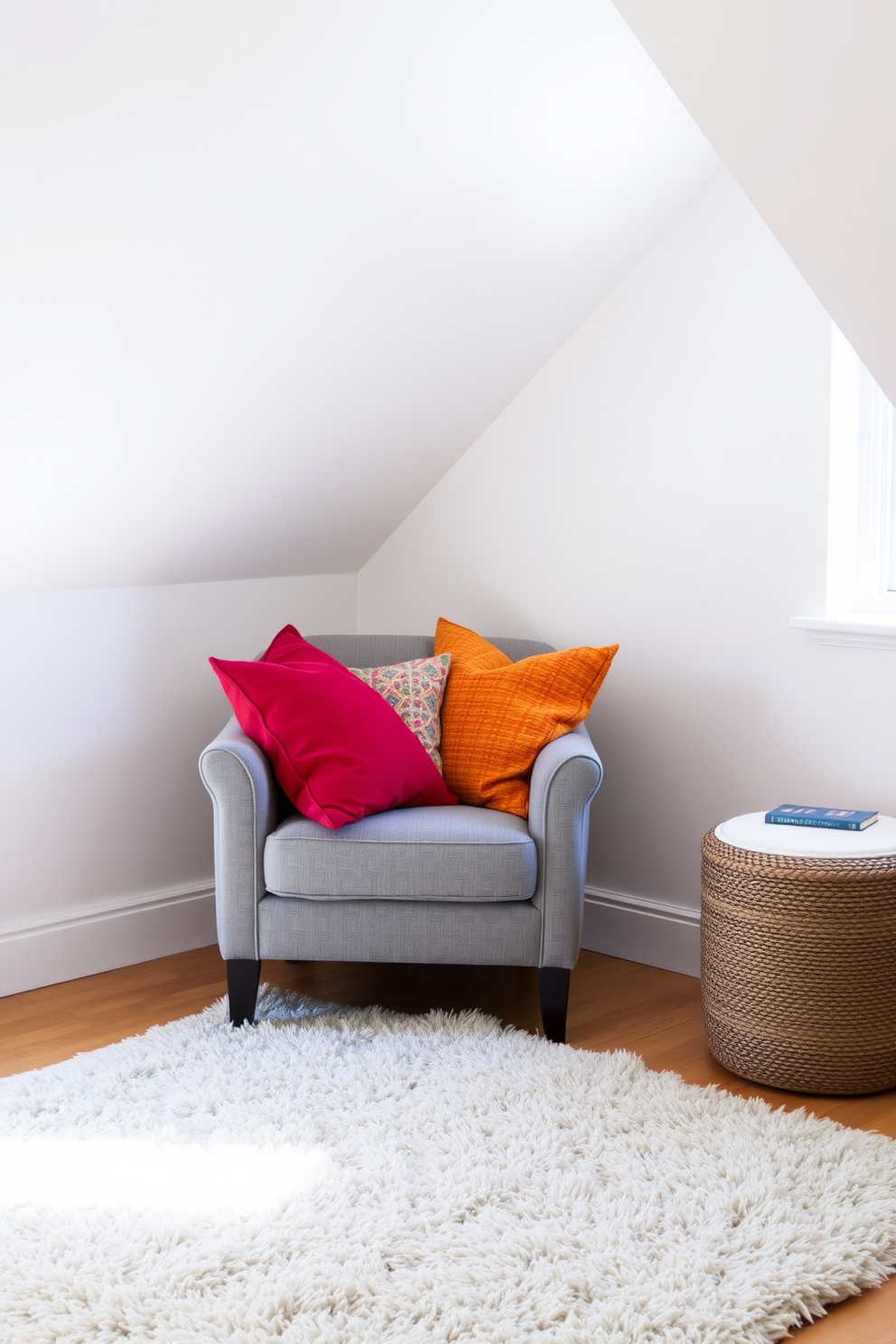 A cozy gray armchair is positioned in the corner of a bright attic room. Colorful throw pillows are arranged on the chair, adding a playful touch to the space. The walls are painted in soft white, enhancing the natural light that fills the room. A plush area rug anchors the seating area, creating a warm and inviting atmosphere.