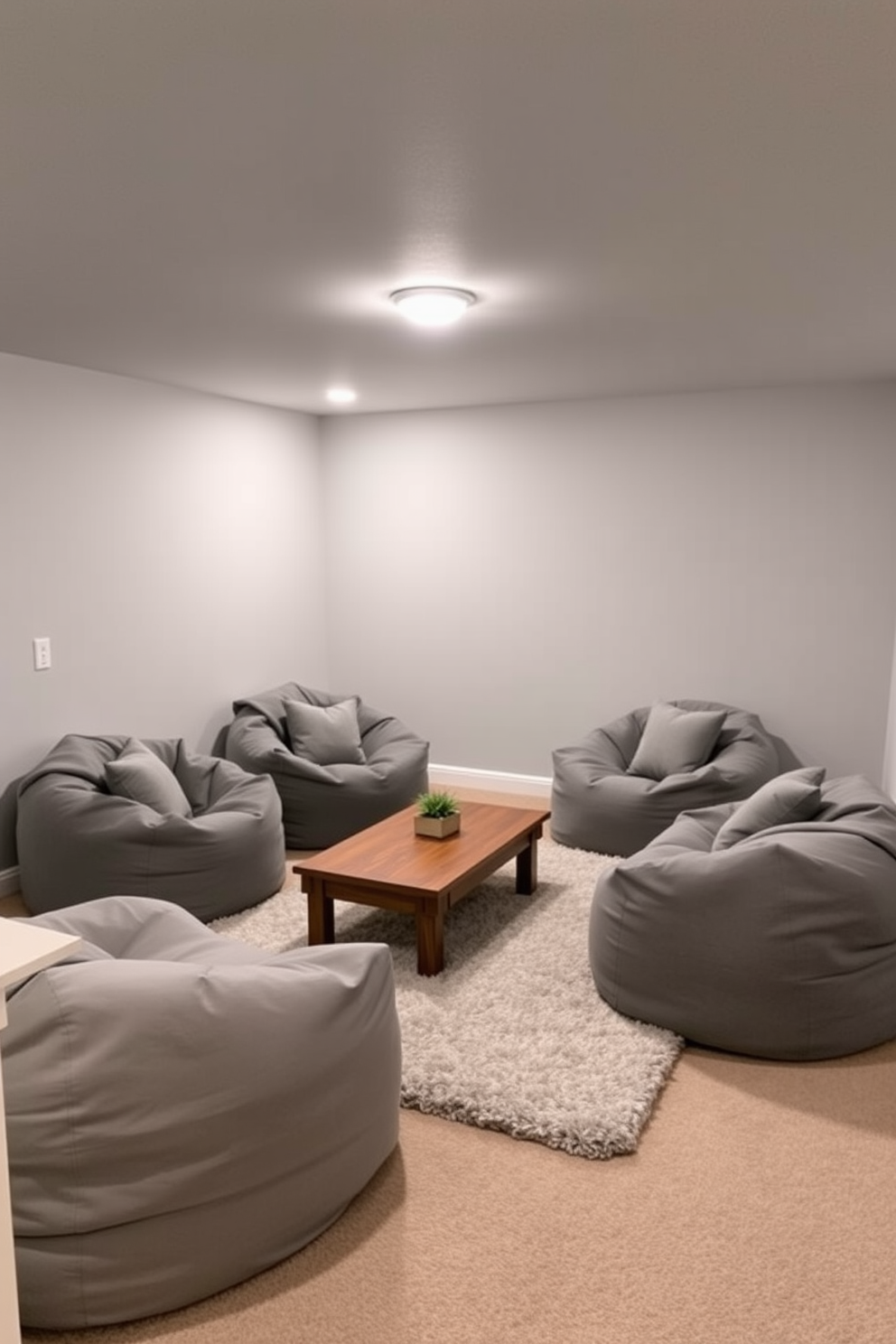 A cozy gray basement featuring soft gray bean bag chairs arranged around a low wooden coffee table. The walls are painted in a light gray hue, and the floor is covered with a plush area rug that adds warmth to the space.