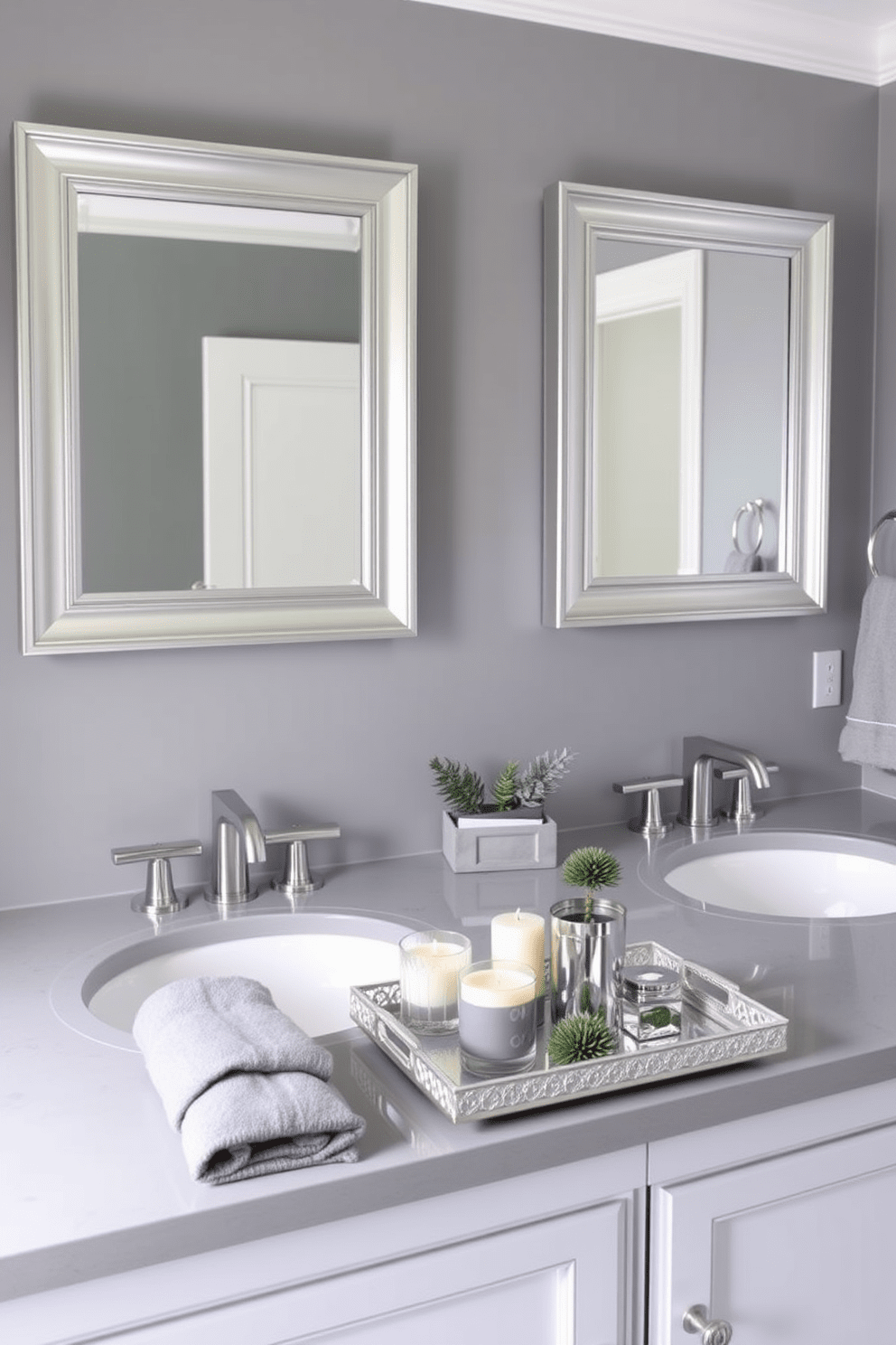 A chic gray bathroom featuring sleek silver accessories that enhance its elegance. The walls are painted in a soft gray hue, complemented by a luxurious silver-framed mirror above the vanity. The vanity is adorned with a polished gray countertop, and stylish silver fixtures are installed on the sinks. Elegant gray towels are neatly displayed, while a silver decorative tray holds scented candles and small plants.