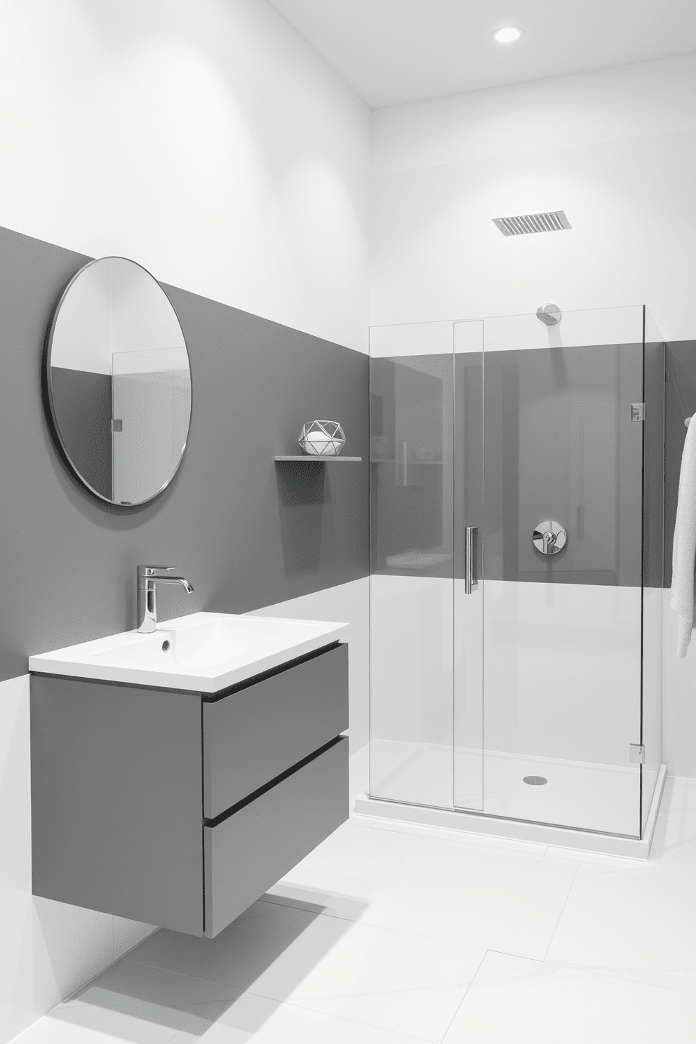 A modern gray bathroom featuring a striking color block design with alternating gray and white walls. The floor is adorned with large white tiles, and a sleek gray vanity with a white countertop is positioned against one wall. A frameless glass shower enclosure is located in the corner, showcasing a rainfall showerhead. Minimalist decor elements, such as a round mirror and geometric shelving, enhance the contemporary aesthetic.