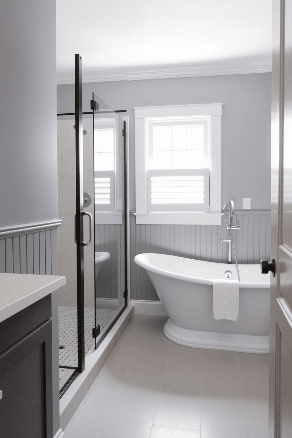 A stylish gray bathroom featuring painted beadboard that adds a classic touch. The space includes a freestanding soaking tub, complemented by a modern shower with glass doors and sleek fixtures.