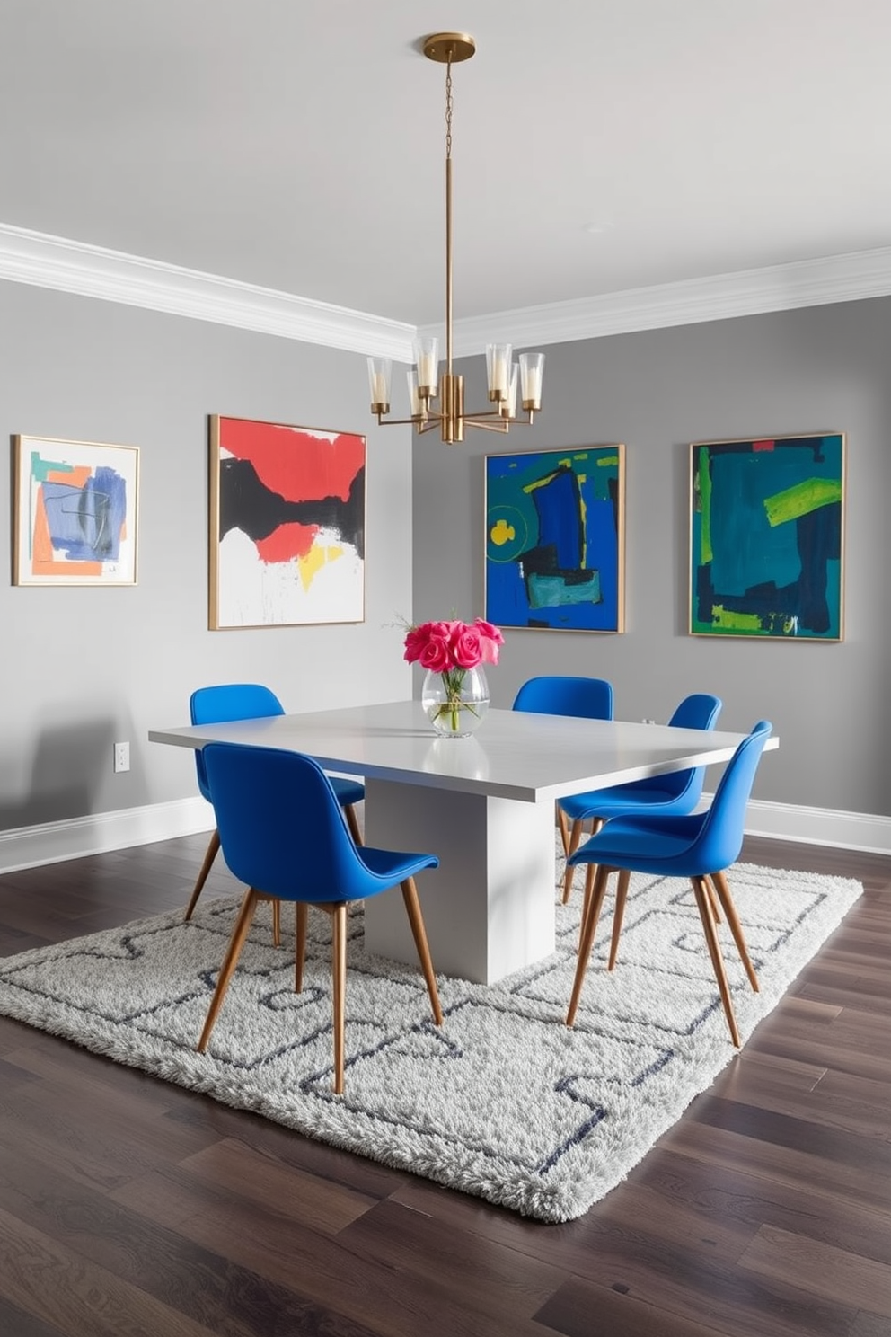 A stylish gray dining room featuring a sleek rectangular table with vibrant blue chairs that add a striking contrast. The walls are adorned with abstract art pieces in bold colors, enhancing the room's modern aesthetic. A contemporary chandelier hangs above the table, providing warm lighting that complements the gray tones. A plush area rug with geometric patterns anchors the space, adding texture and comfort to the dining area.