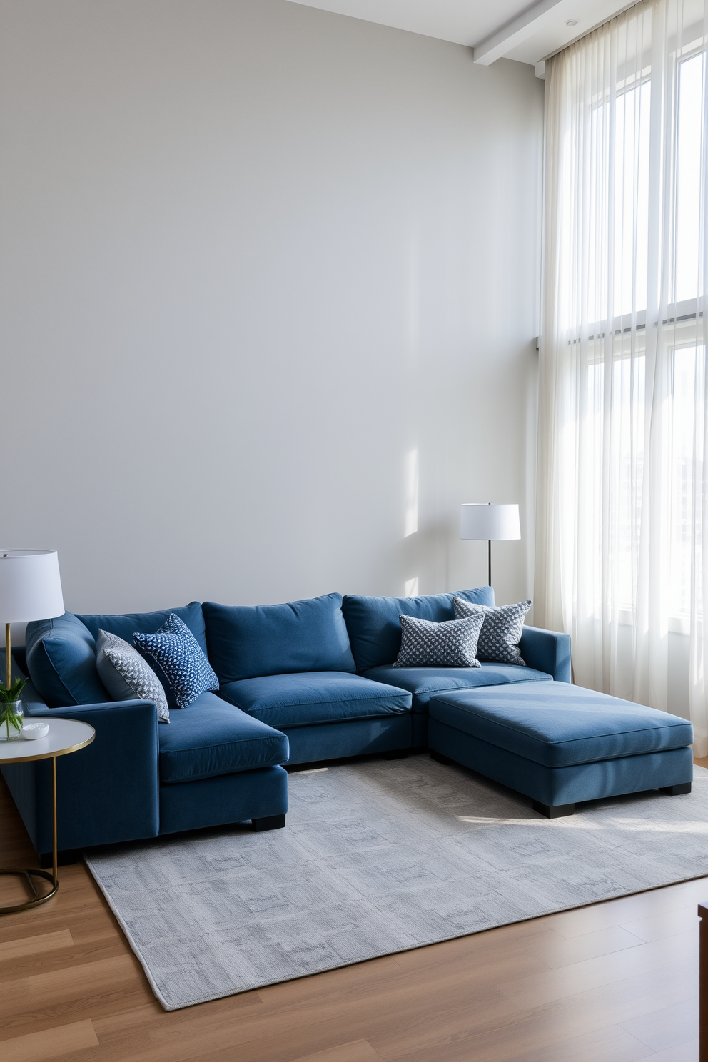 A serene family room featuring a gray and blue color palette that promotes tranquility. The walls are painted a soft gray, while a plush blue sectional sofa is positioned in the center of the room. A large area rug with subtle patterns anchors the seating area, complemented by gray and blue throw pillows. Natural light filters through sheer curtains, illuminating the space and enhancing the calming atmosphere.