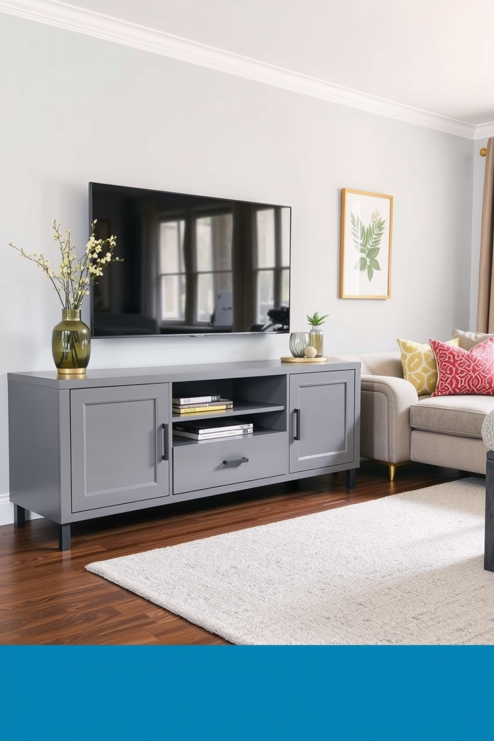 A modern gray media console with sleek lines and ample storage sits against a light gray wall. The family room features a cozy sectional sofa in a complementary shade, accented with colorful throw pillows and a soft area rug.