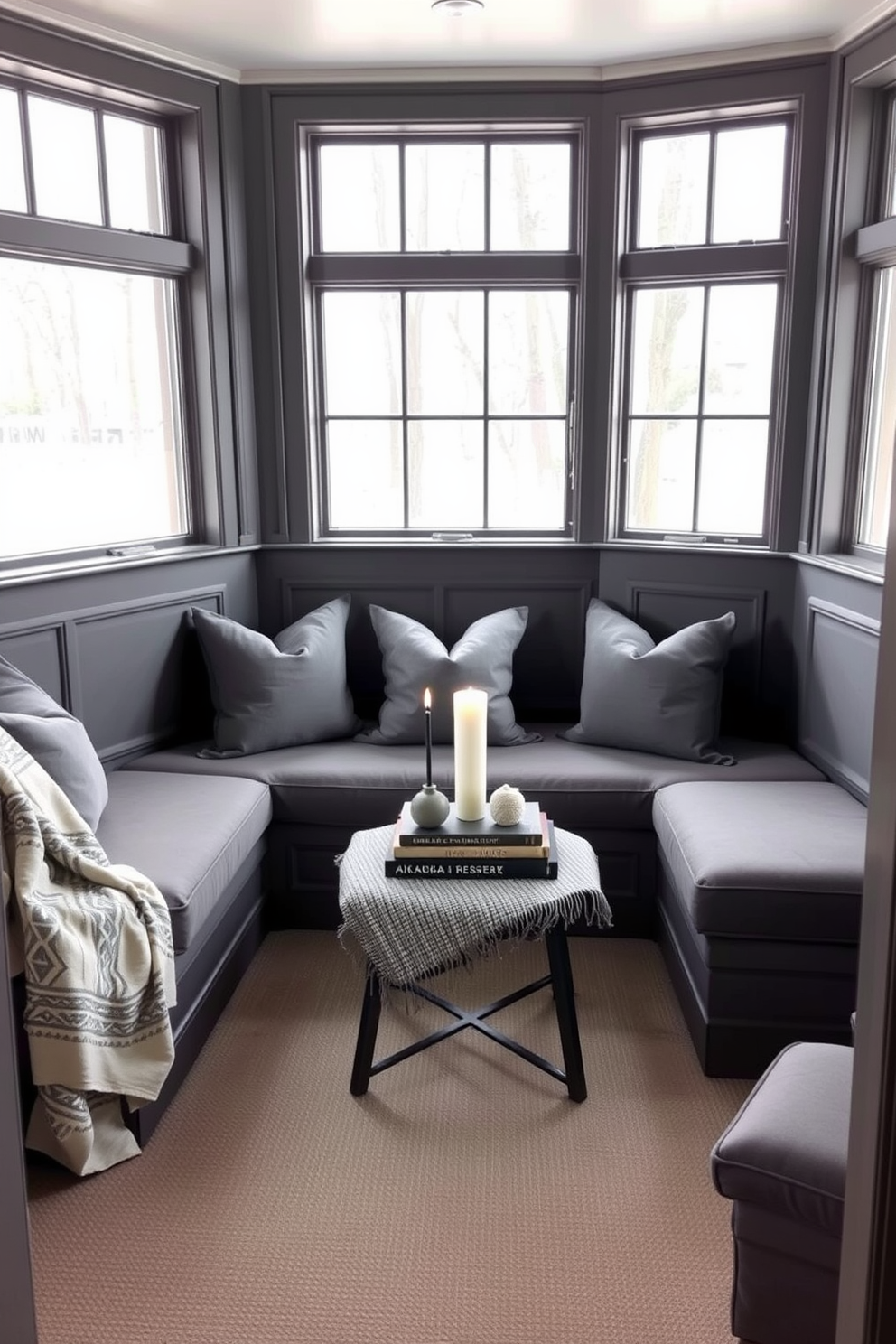 Cozy gray nook with built-in seating. The space features plush gray cushions and a soft throw blanket, creating a warm and inviting atmosphere. Large windows allow natural light to flood the room, highlighting the subtle textures of the gray upholstery. A small coffee table sits in the center, adorned with a few decorative books and a candle for added charm.