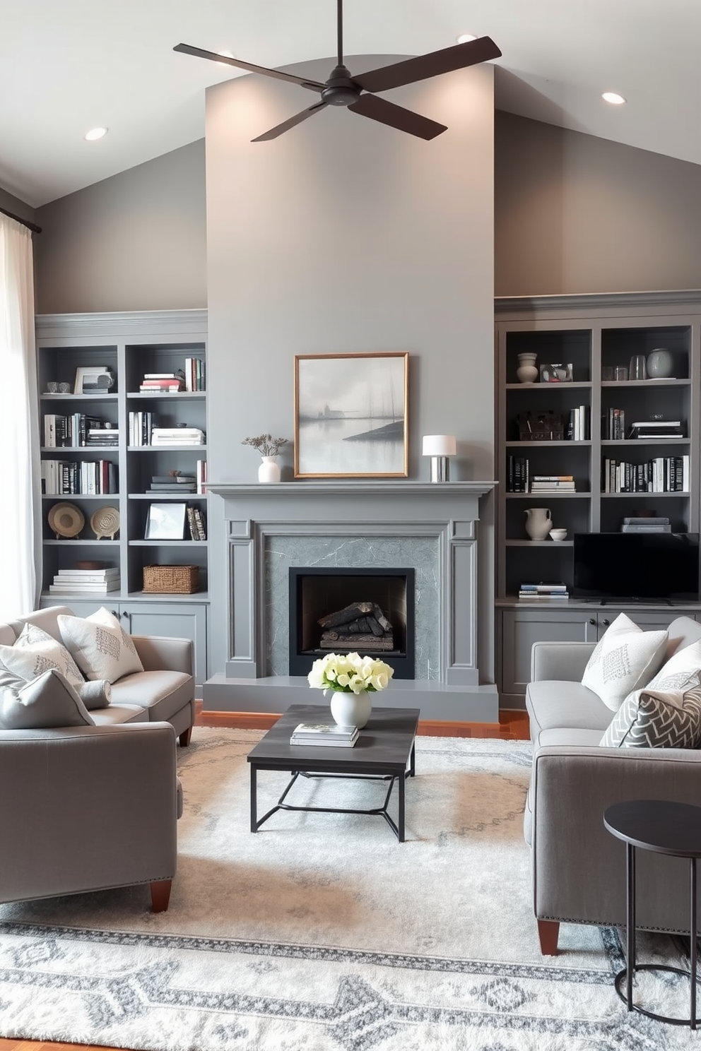 A cozy family room featuring a gray fireplace as the focal point. Built-in shelving flanks the fireplace, showcasing books and decorative items, creating an inviting atmosphere. The walls are painted in a soft gray hue, complemented by plush seating in varying shades of gray and white. A large area rug anchors the space, while natural light filters through sheer curtains, enhancing the room's warmth.