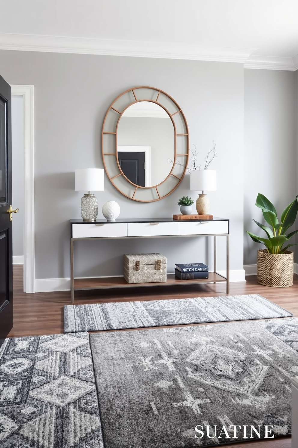 A stylish foyer featuring layered gray rugs that add depth and texture to the space. The walls are painted in a soft gray hue, complemented by a sleek console table adorned with decorative items and a statement mirror above it.