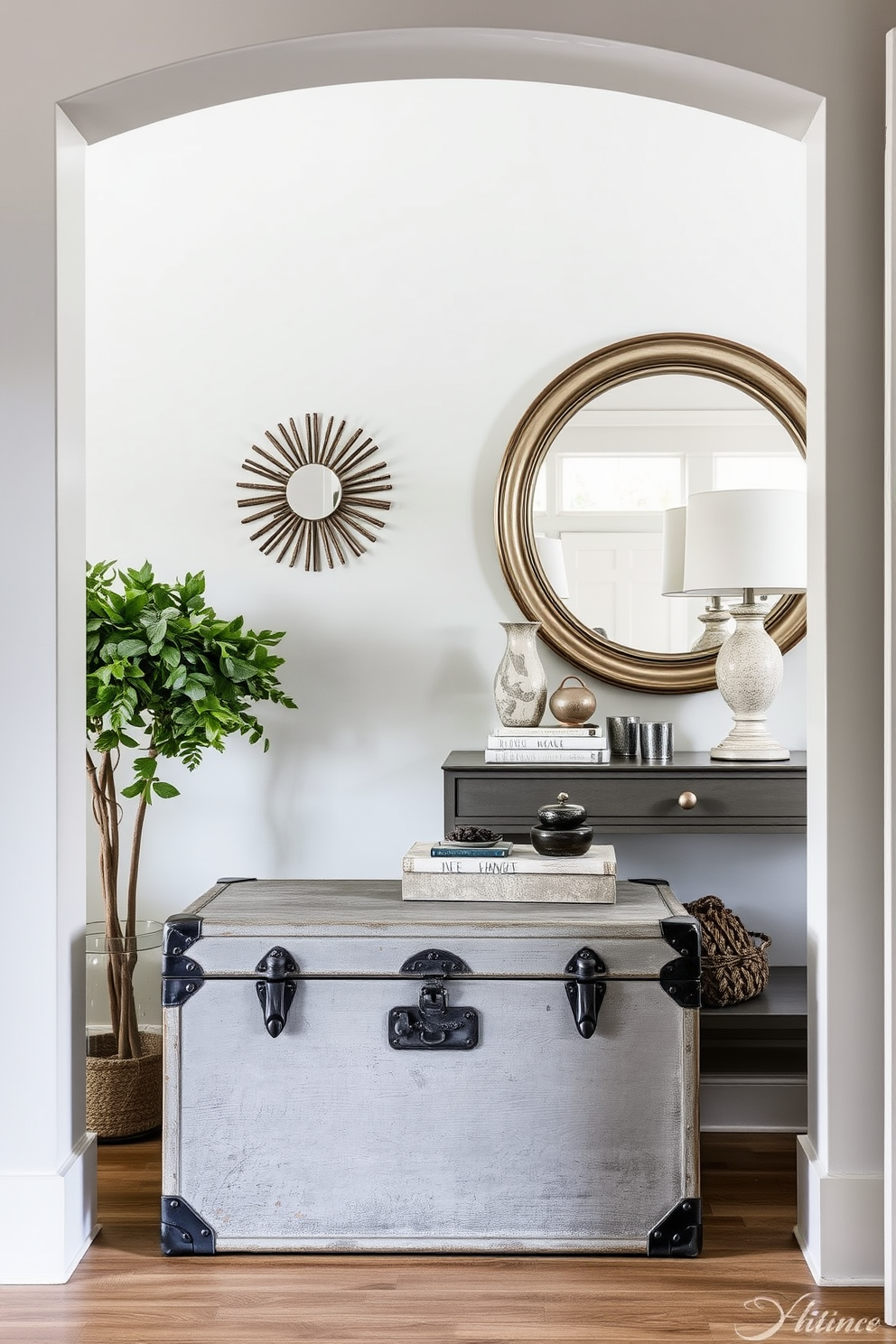 A vintage gray trunk sits elegantly in the foyer, serving as both a stylish storage solution and a decorative accent. The trunk's weathered finish complements the soft gray walls, creating a cohesive and inviting entryway. In the foyer, a chic arrangement of vintage-inspired decor enhances the overall aesthetic. A sleek console table against the wall showcases curated accessories, while a large mirror reflects natural light, making the space feel more expansive.