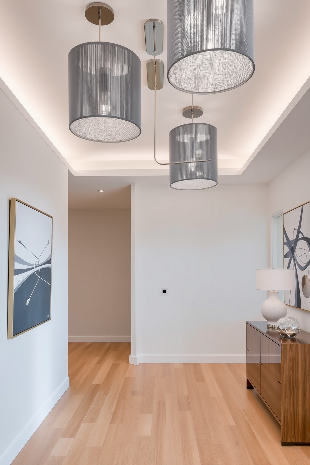 A contemporary foyer featuring sleek gray lighting fixtures that enhance the elegance of the space. The walls are adorned with minimalist art pieces, and the flooring is a polished light wood that complements the overall design.