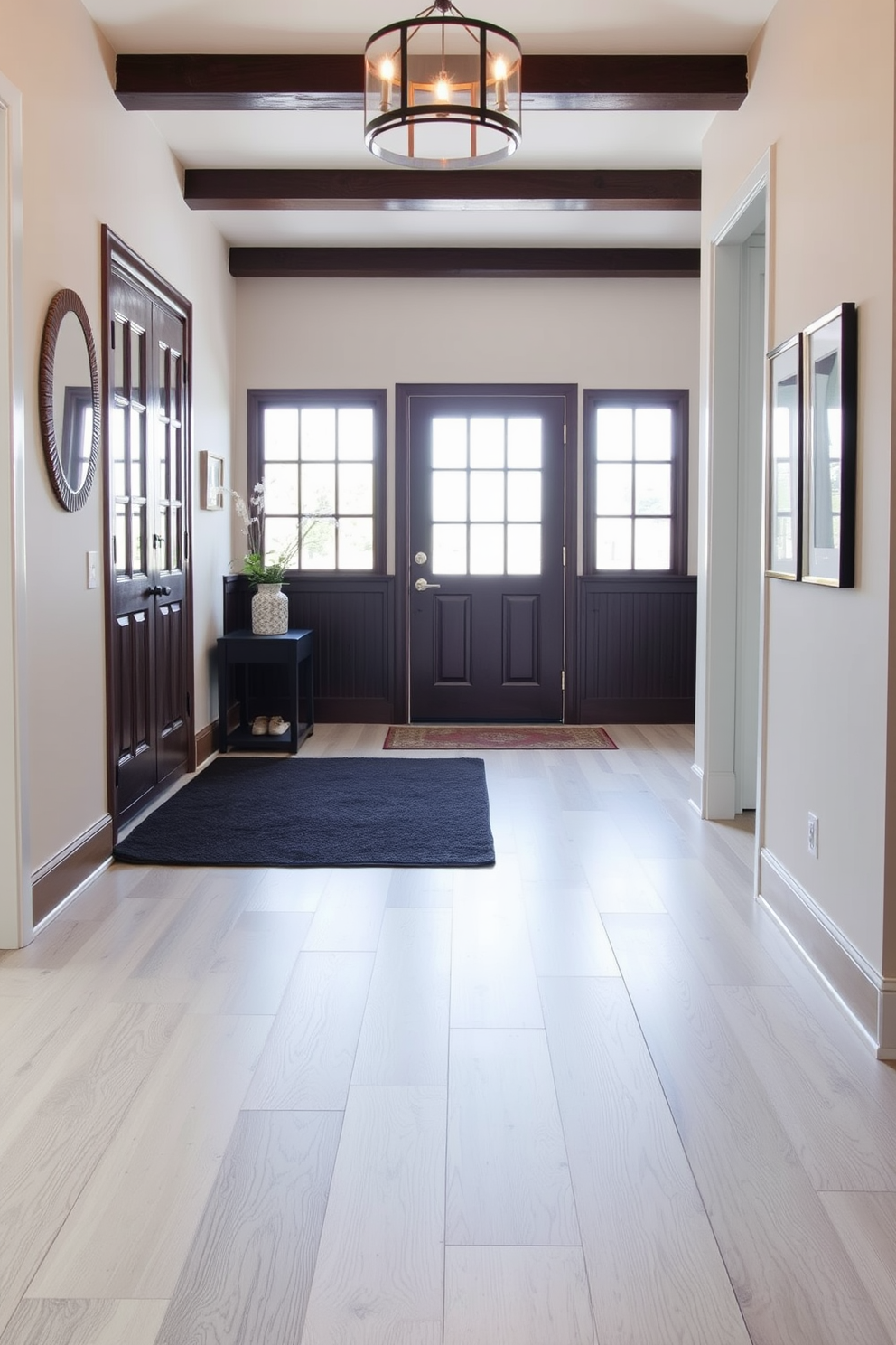 A contemporary foyer with light gray flooring that creates a spacious and inviting atmosphere. A dark area rug adds contrast and warmth, defining the entryway space while complementing the overall design.