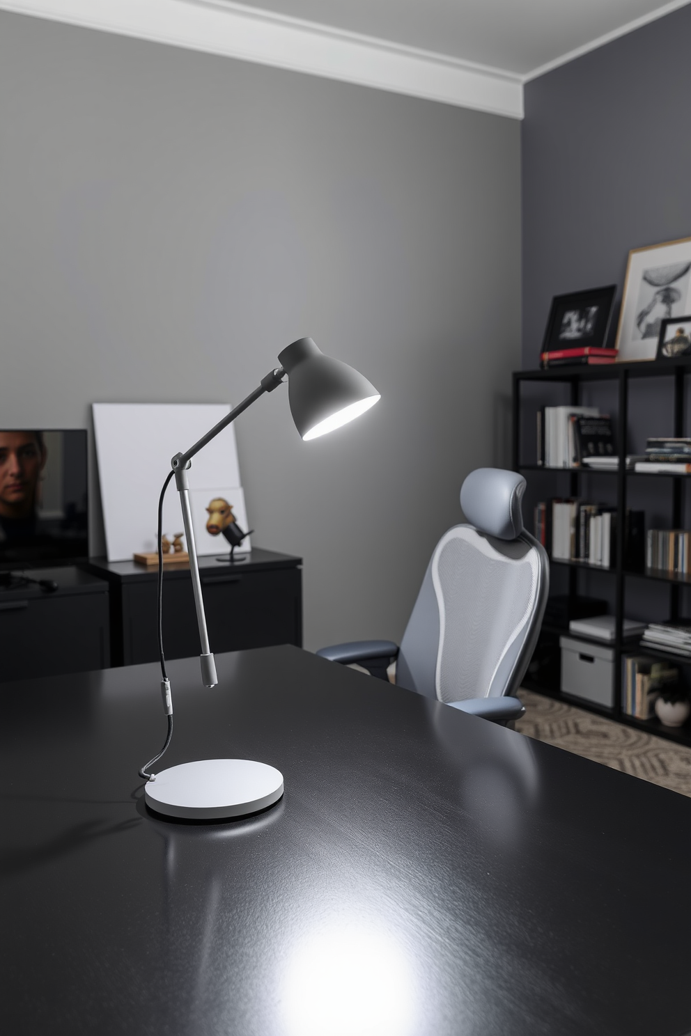 A stylish gray desk lamp stands elegantly on a sleek black desk, providing focused lighting for an inspiring workspace. The home office features a minimalist design with gray walls, a comfortable ergonomic chair, and organized shelves filled with books and decorative items.