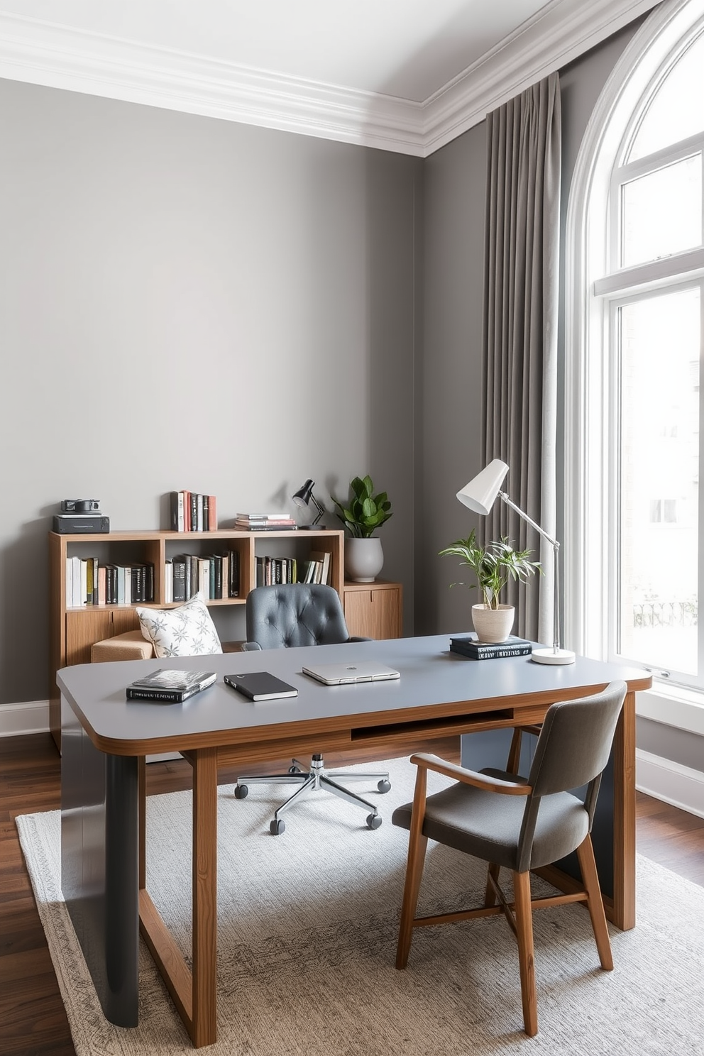 A stylish gray desk with natural wood accents sits in the center of a modern home office. The walls are painted in a soft gray hue, complemented by a large window that allows natural light to flood the space. To the left of the desk, there is a cozy reading nook with a plush armchair and a small bookshelf filled with curated books. Decorative elements include a potted plant and a sleek desk lamp that adds a touch of sophistication.