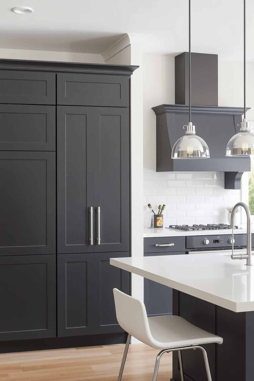 A modern kitchen featuring dark gray cabinets paired with bright white countertops. The space is illuminated by pendant lights hanging above an island with bar seating, creating a welcoming atmosphere.