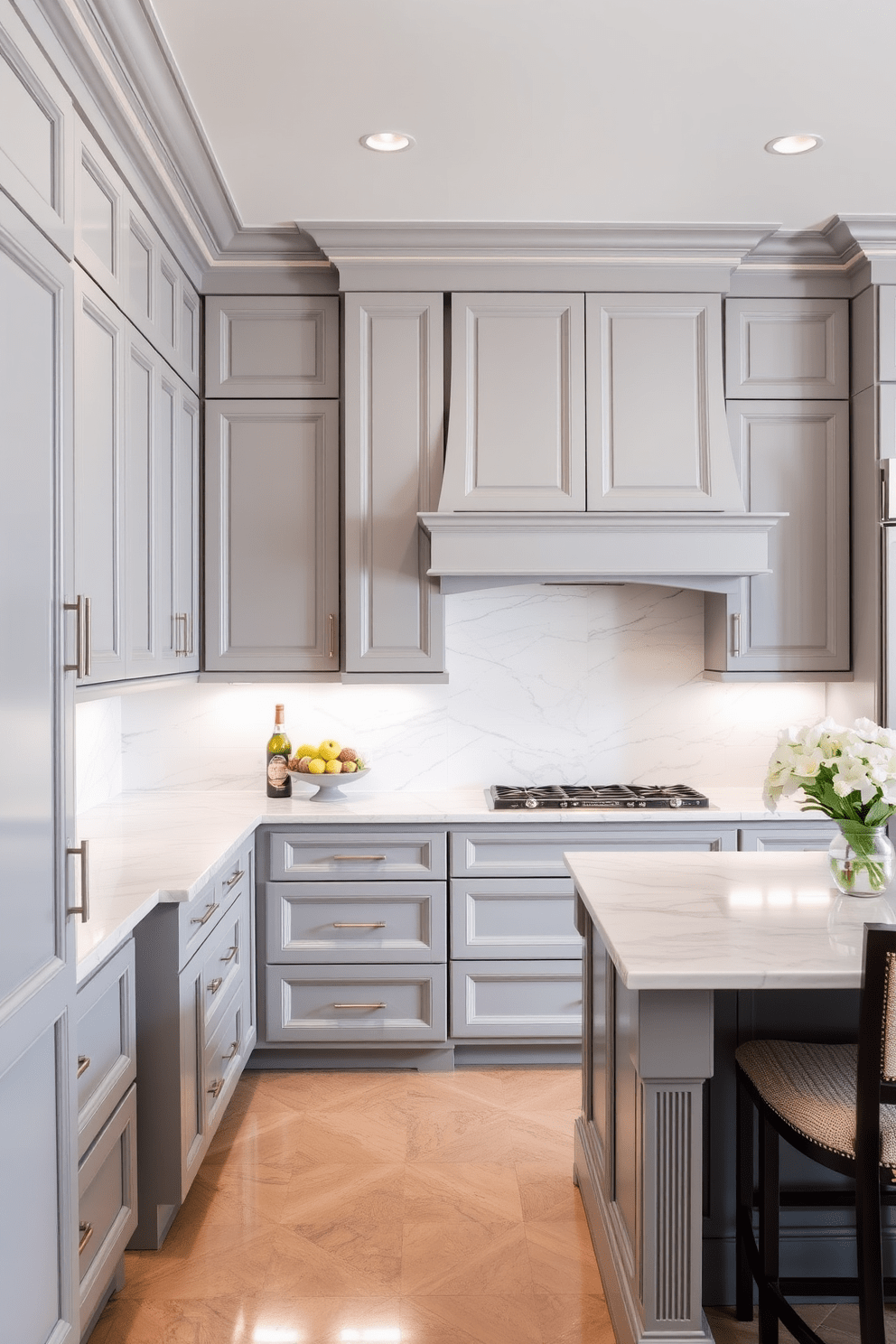 An elegant gray kitchen featuring decorative moldings that add a touch of sophistication. The cabinetry is a soft gray with sleek hardware, complemented by a marble backsplash and a spacious island with bar seating.