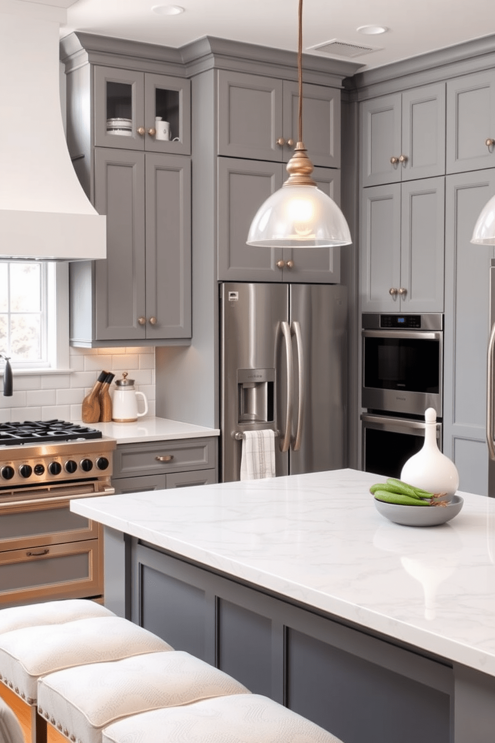 Chic gray cabinetry with decorative hardware creates a modern and elegant kitchen atmosphere. The cabinetry is complemented by sleek stainless steel appliances and a white subway tile backsplash for a fresh look. A large kitchen island with a marble countertop serves as the centerpiece of the space. Pendant lights hang above, providing warm illumination and enhancing the sophisticated ambiance.