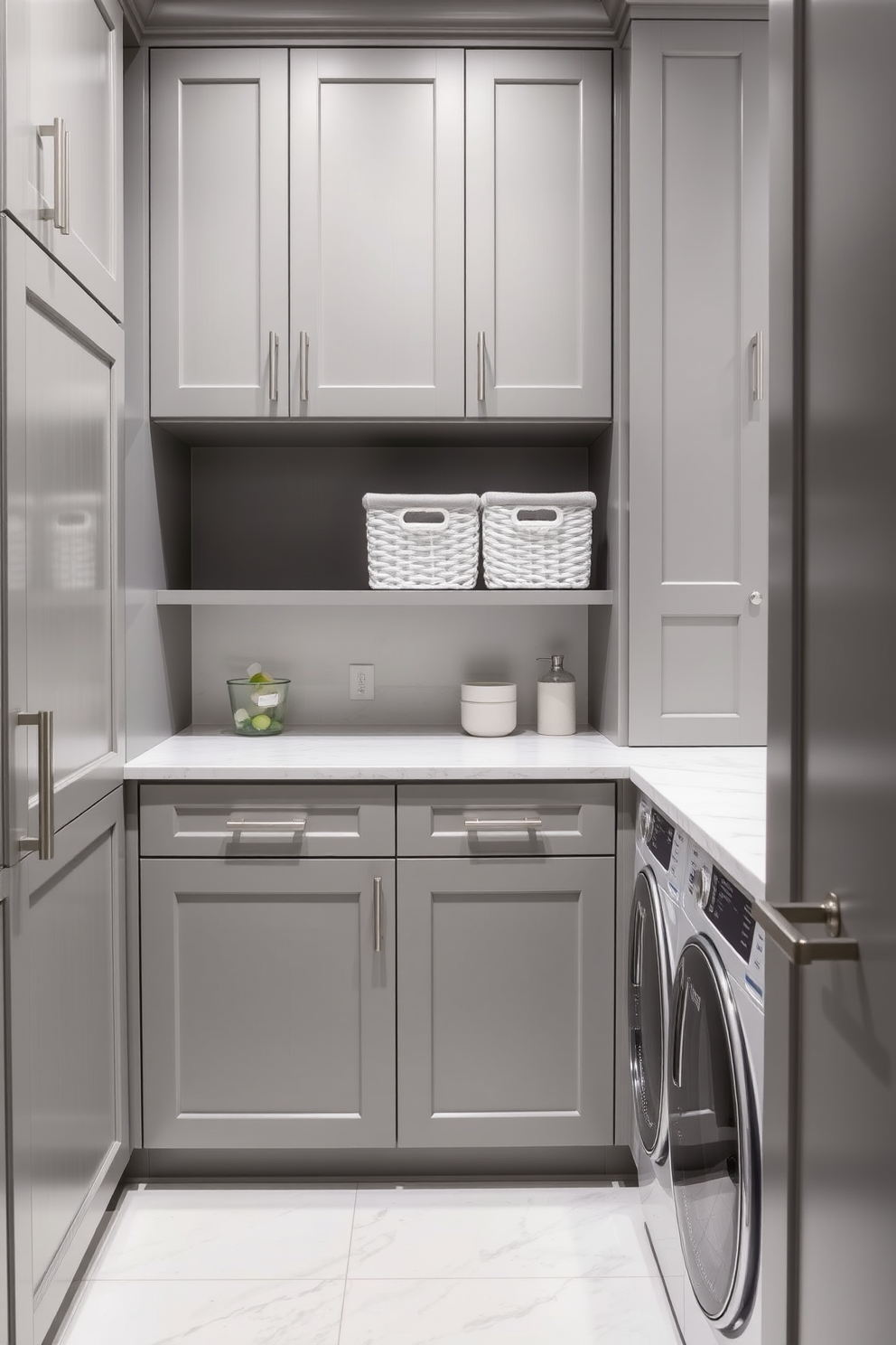 A sleek laundry room featuring cabinetry that seamlessly integrates laundry baskets for a clean and organized look. The cabinetry is finished in a soft gray hue, complemented by brushed nickel hardware and a marble countertop for added elegance.