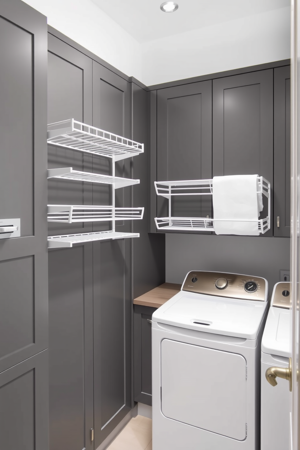 A modern laundry room featuring wall-mounted drying racks for convenience. The space is designed with sleek gray cabinetry and a minimalist aesthetic, creating a functional yet stylish environment.