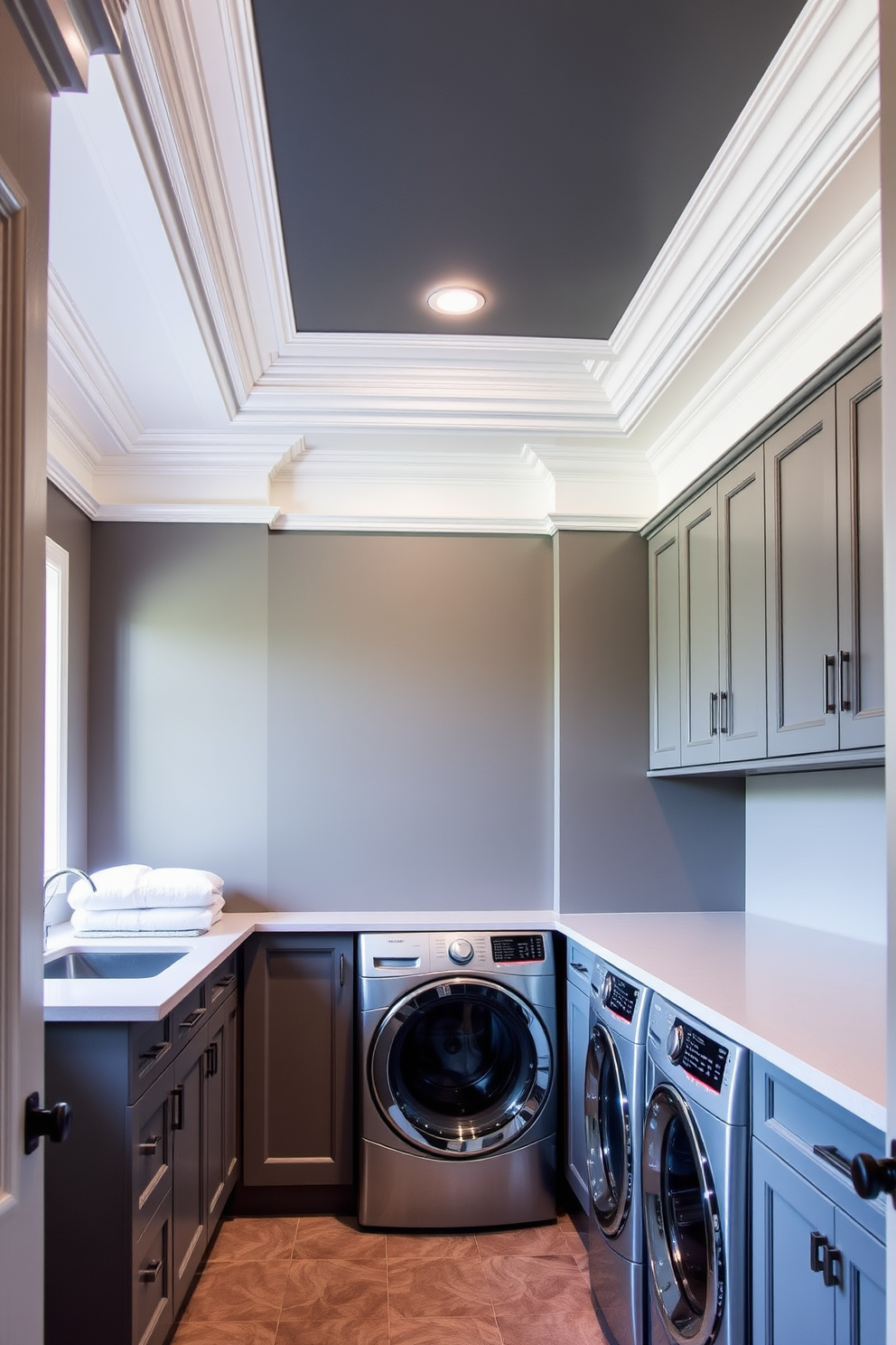 A stylish gray laundry room featuring elegant crown molding along the ceiling. The space includes a sleek countertop for folding clothes and ample cabinetry for storage.