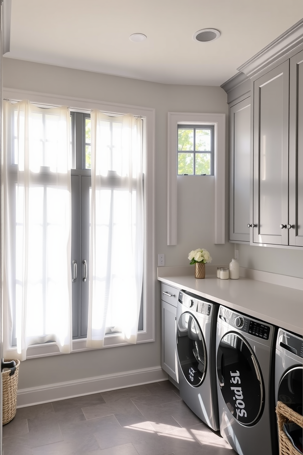 Bright window treatments for natural light. The laundry room features large windows adorned with sheer white curtains that allow sunlight to flood the space, creating an airy and inviting atmosphere. Gray laundry room design ideas include sleek gray cabinetry and a stylish countertop for folding clothes. The floor is finished with a durable gray tile, while decorative storage baskets add a touch of warmth and organization.