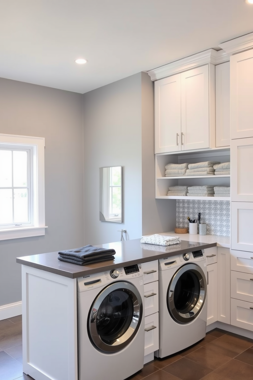 A functional laundry island designed for folding clothes is the centerpiece of a modern gray laundry room. The island features a sleek countertop with ample space for sorting and folding, surrounded by built-in storage cabinets for laundry essentials. The walls are painted in a soft gray hue, complemented by white cabinetry that enhances the room's brightness. A stylish backsplash with a subtle pattern adds visual interest, while a large window allows natural light to flood the space.