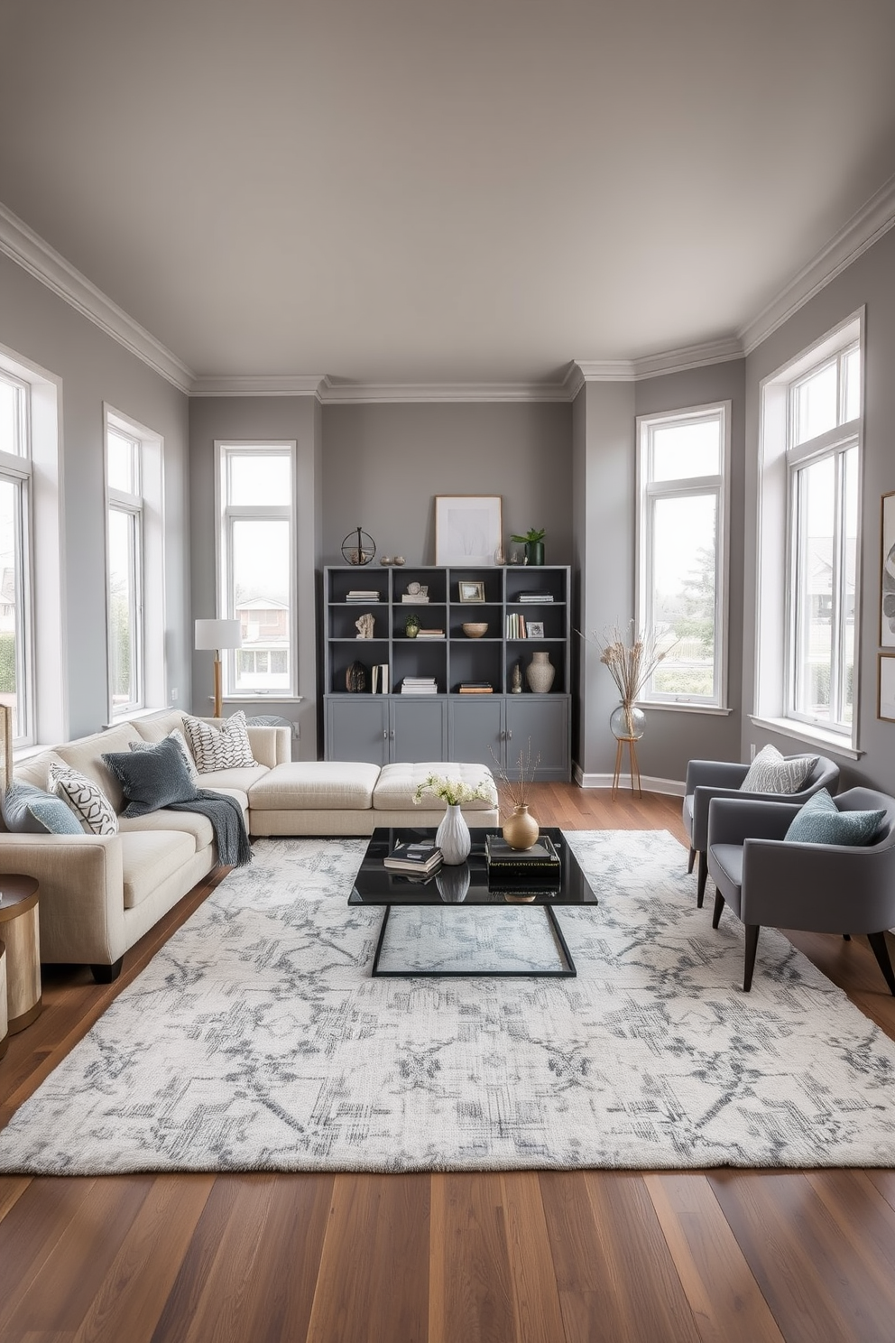 A cozy gray living room featuring a plush beige sectional sofa adorned with decorative throw pillows. The walls are painted in a soft gray hue, complemented by a large area rug that brings warmth to the space. In the corner, a sleek modern coffee table sits atop the rug, surrounded by stylish accent chairs. Natural light floods the room through large windows, highlighting a minimalist bookshelf filled with curated decor and books.