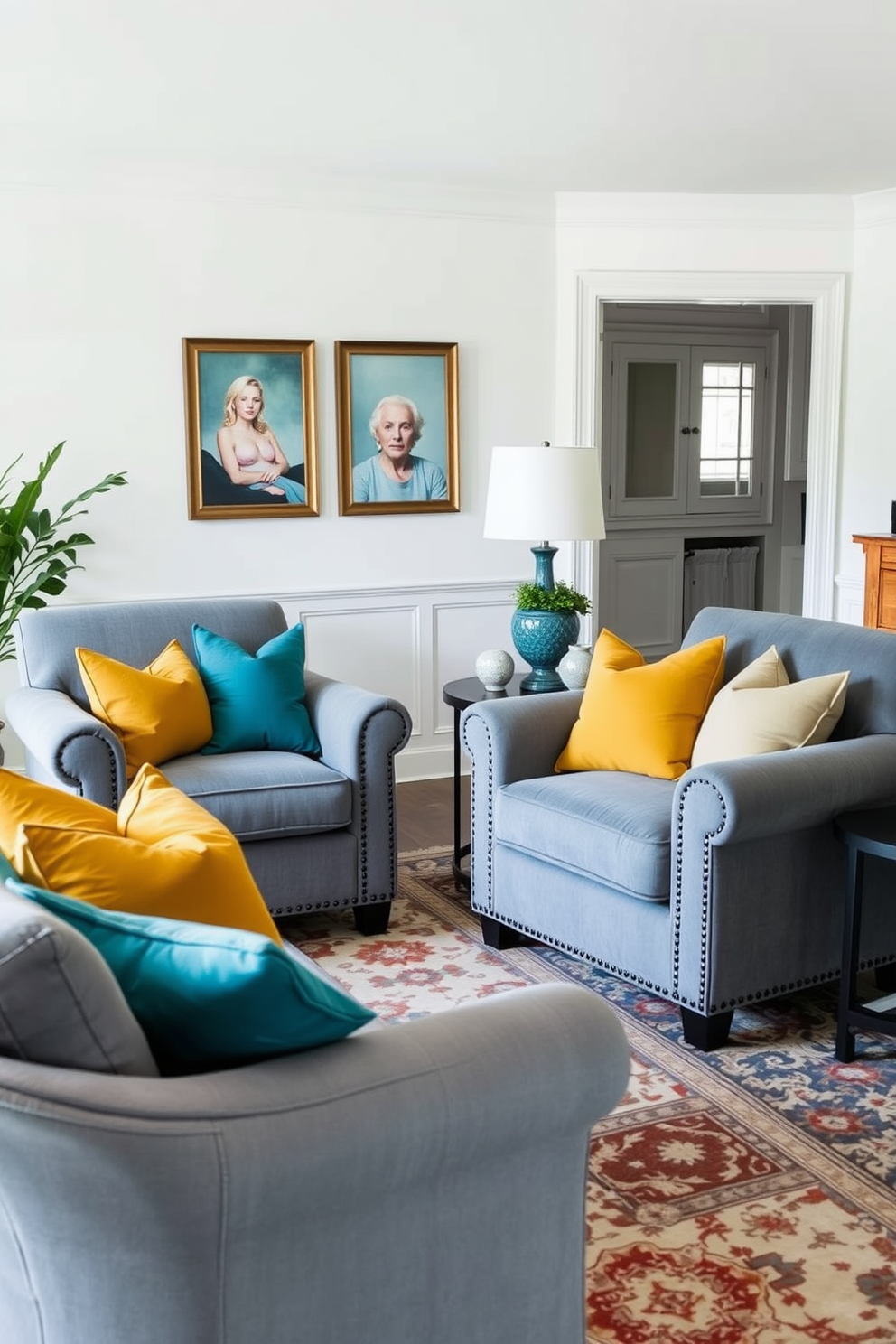 A cozy living room featuring plush gray armchairs adorned with vibrant cushions in shades of teal and mustard. The walls are painted in a soft white, and a large area rug with intricate patterns anchors the seating arrangement.