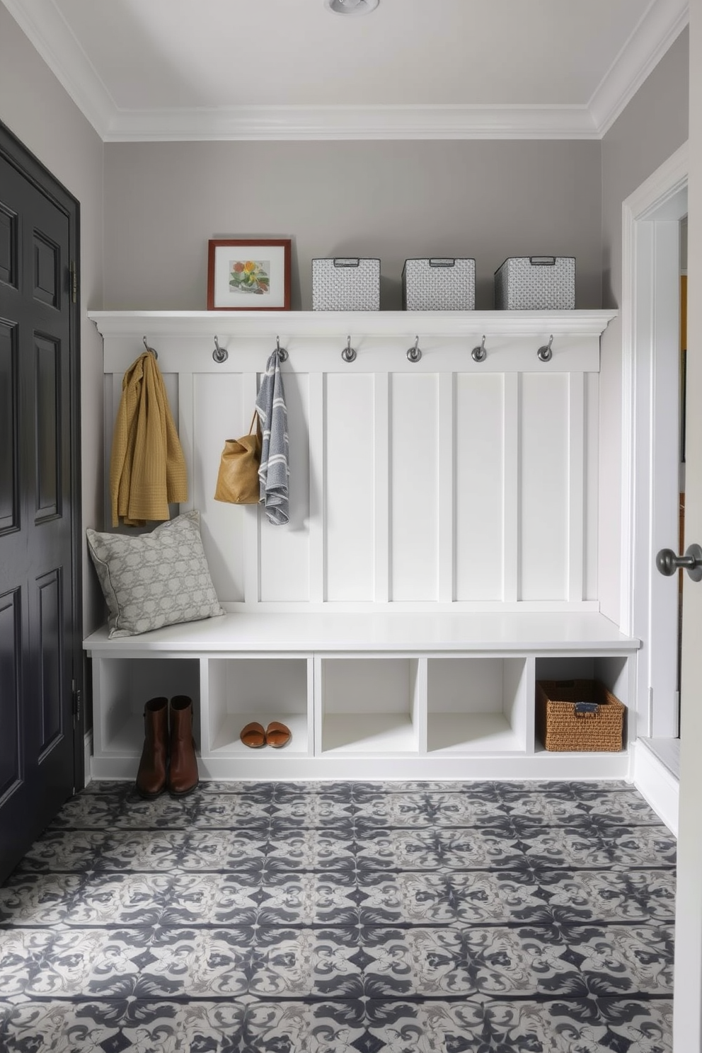 A stylish mudroom featuring gray and black patterned floor tiles that add depth and interest to the space. The walls are painted in a soft gray hue, and a built-in bench with storage cubbies provides functionality and organization.