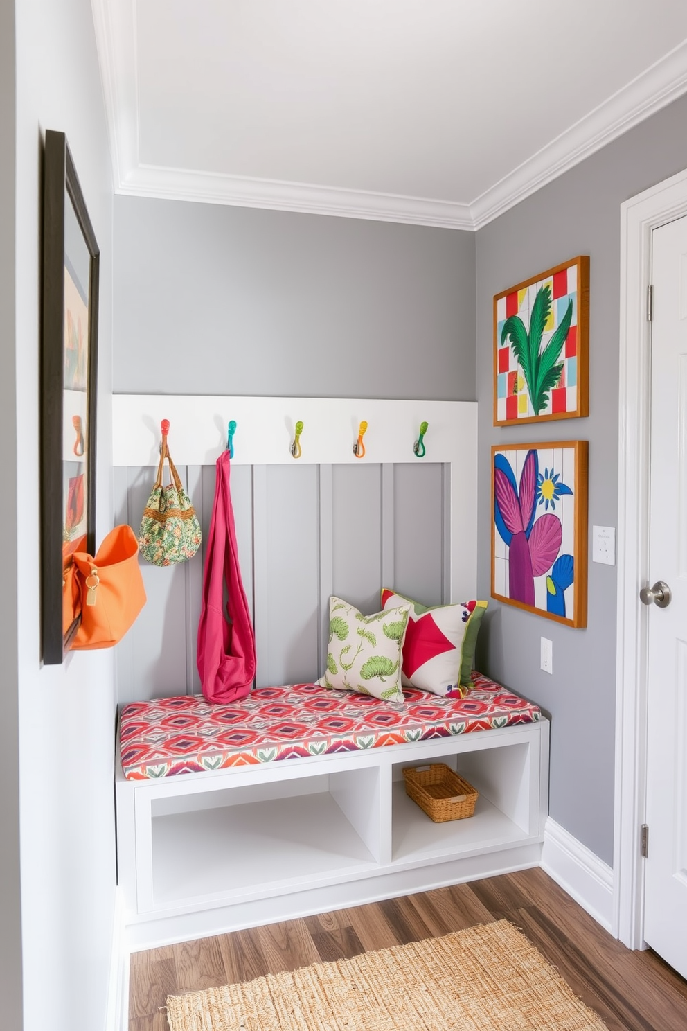 Bright gray walls create a modern backdrop for a stylish mudroom filled with vibrant decor. A combination of colorful hooks, a patterned bench cushion, and lively artwork adds personality and warmth to the space.