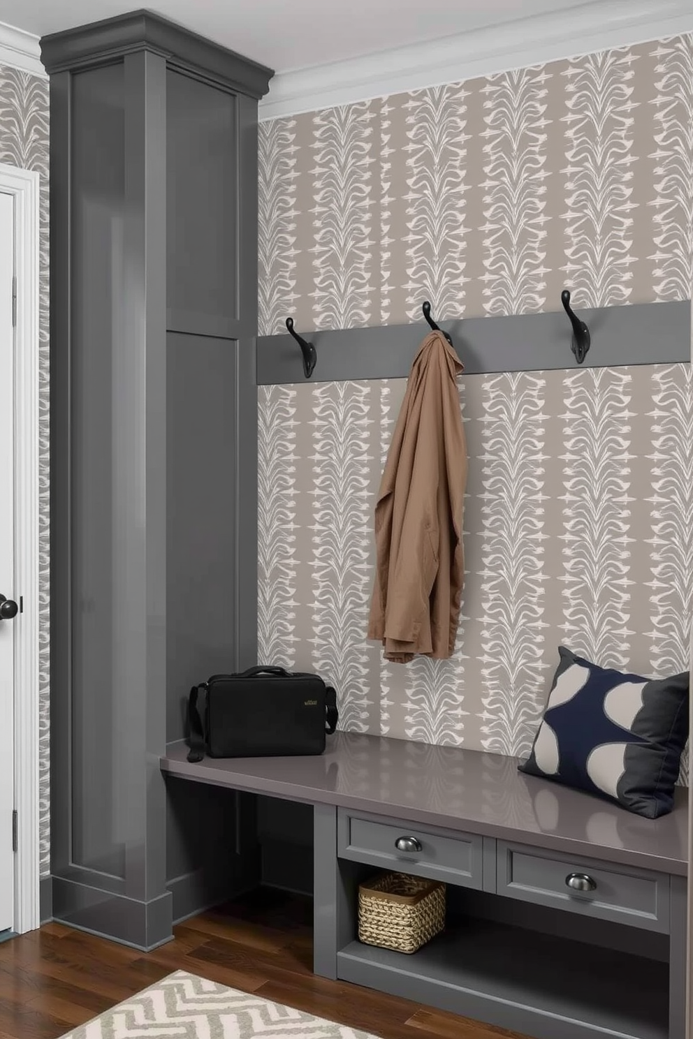 A trendy gray mudroom featuring wallpaper with geometric patterns. The space includes built-in storage benches and hooks for coats, creating a functional yet stylish entryway.