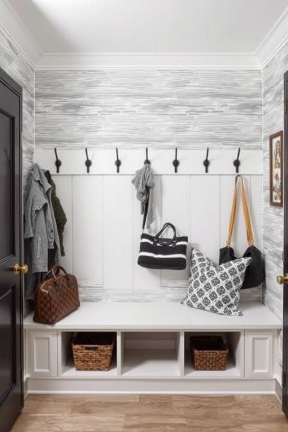 A stylish mudroom featuring gray and white striped wallpaper that adds texture and depth to the space. The room includes a built-in bench with storage underneath and hooks above for coats and bags, creating an organized and inviting entryway.