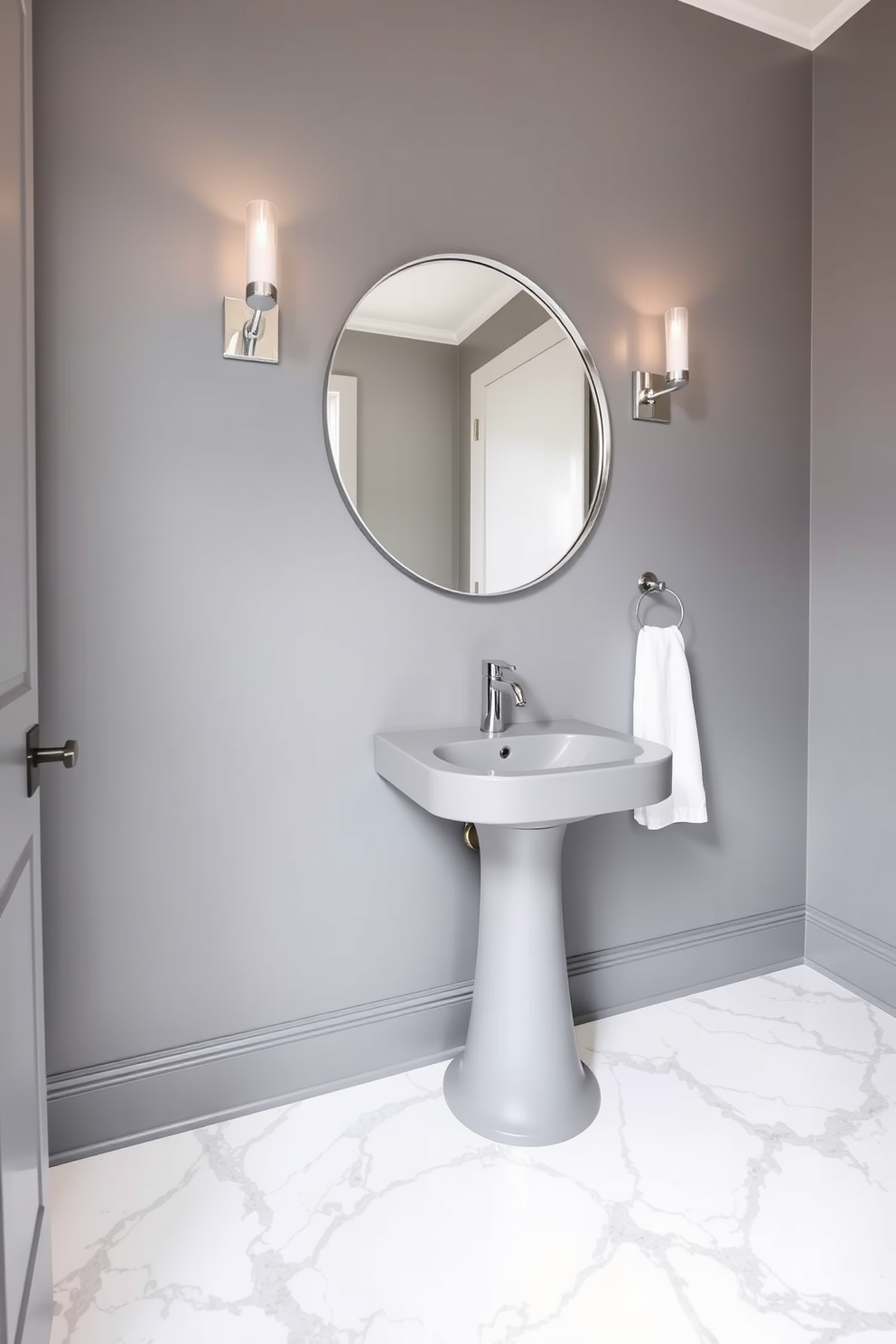 A sophisticated powder room featuring a sleek gray color palette complemented by elegant marble accents. The walls are painted in a soft gray hue, while the floor showcases stunning white marble tiles with subtle gray veining. A contemporary pedestal sink with a polished chrome faucet sits against the wall, topped with a minimalist gray countertop. Above the sink, a large round mirror with a thin silver frame reflects the light from a stylish wall sconce on either side.