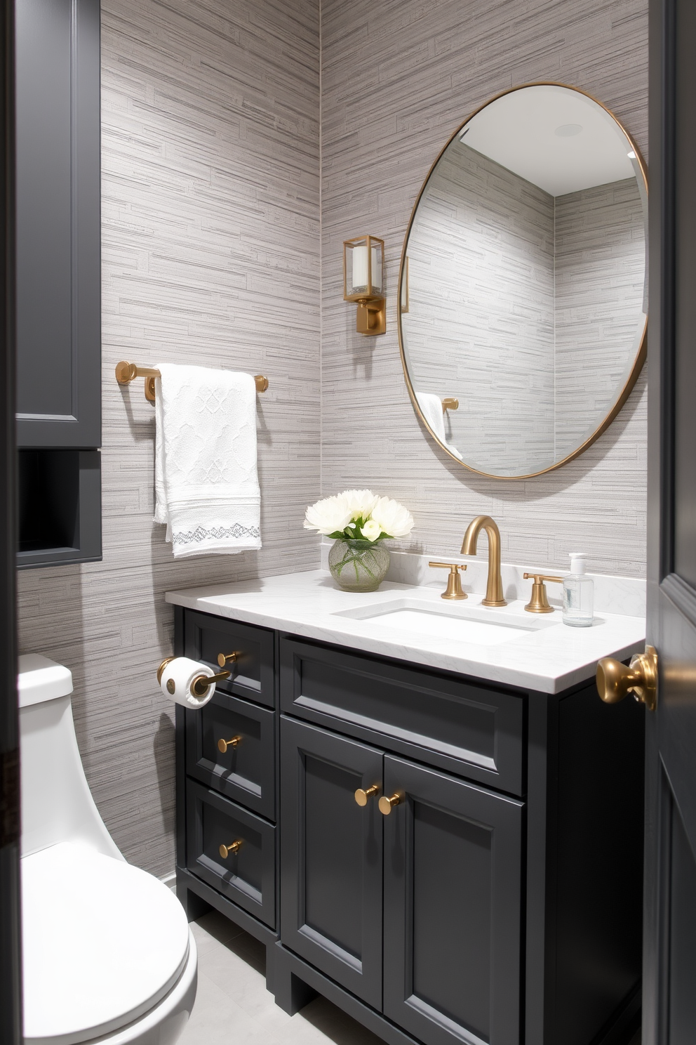 A stylish gray powder room featuring dark gray cabinetry with elegant brass hardware. The walls are adorned with a subtle textured wallpaper, creating depth and sophistication in the space.