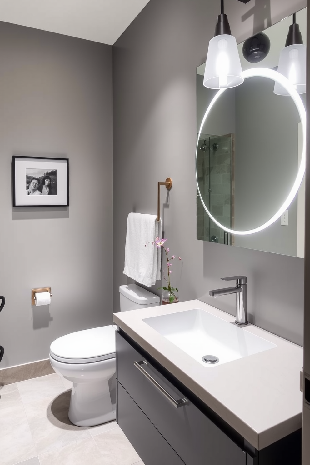 A modern floating sink is installed with sleek gray cabinetry beneath it. The powder room features minimalist decor with elegant lighting and a large mirror that enhances the space.