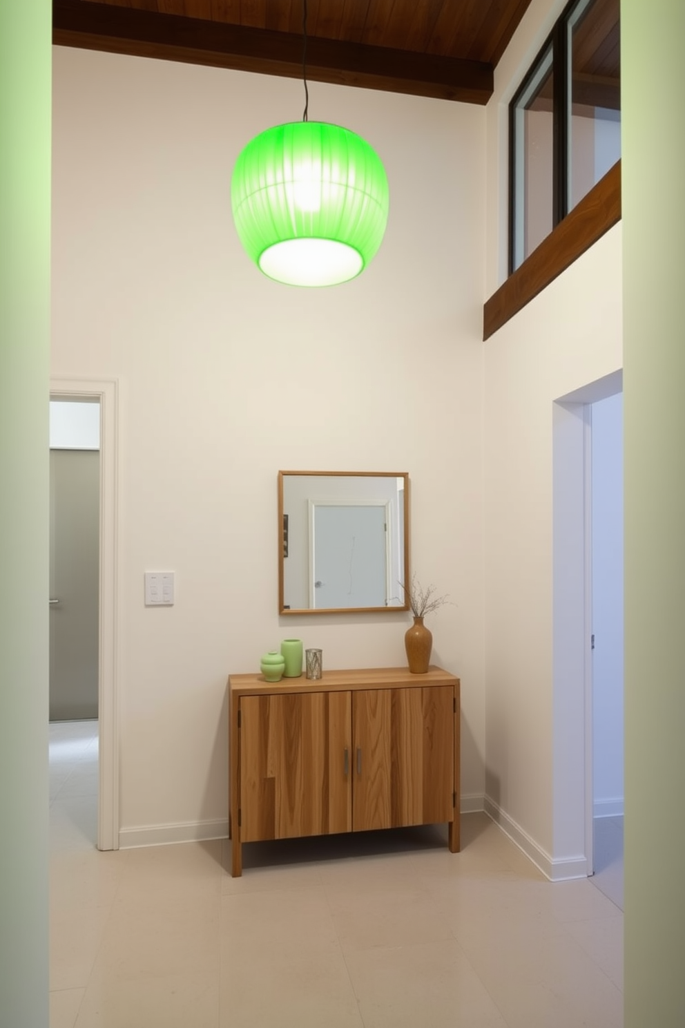 A bright green pendant light fixture hangs elegantly from the ceiling, casting a vibrant glow over the foyer. The walls are painted in a soft white, creating a fresh backdrop that enhances the light's color. The foyer features a sleek console table made of natural wood, adorned with a few decorative items in complementary shades. A large mirror with a minimalist frame reflects the light, making the space feel open and inviting.