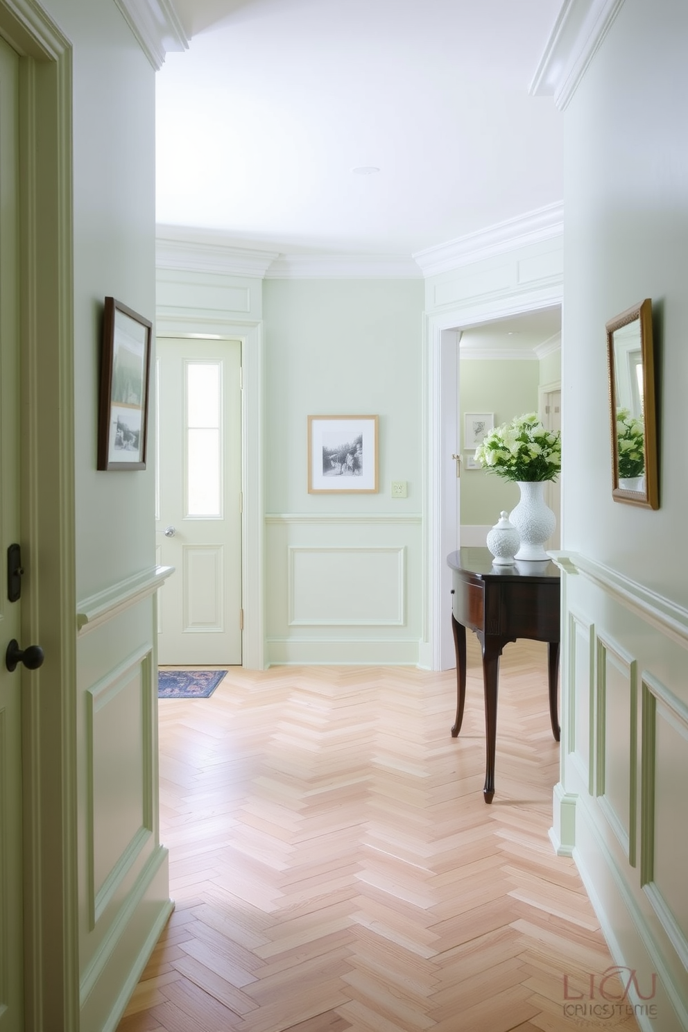 A light green foyer featuring elegant wainscoting that adds a touch of sophistication to the space. The floor is adorned with a classic herringbone pattern in light wood, complementing the soft green tones of the walls.