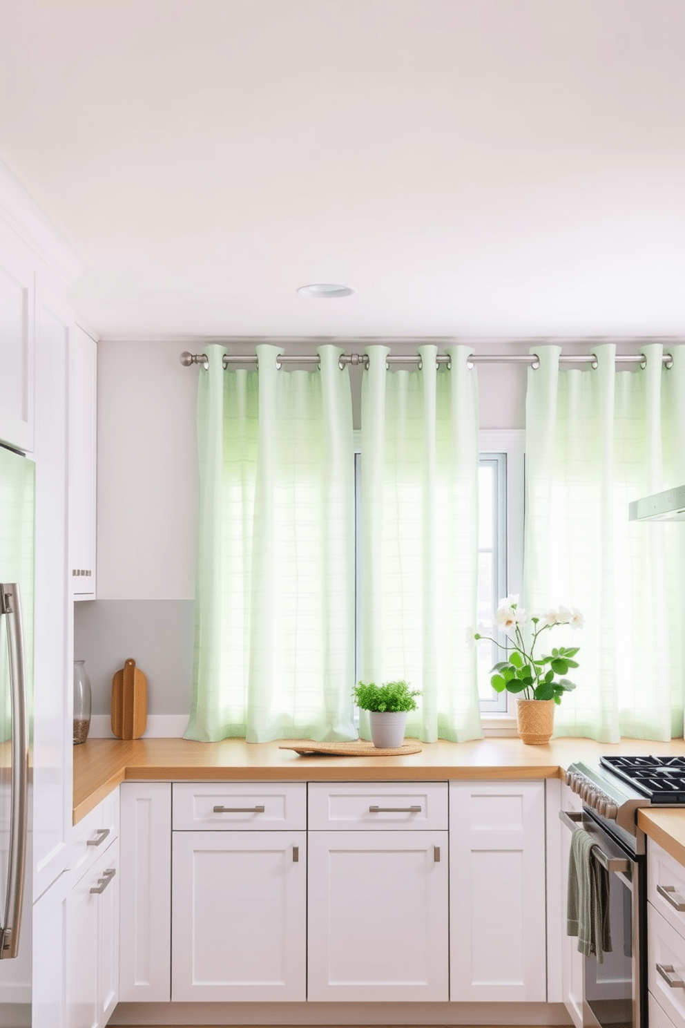 A fresh kitchen design featuring soft mint green curtains that gently filter natural light. The cabinetry is a crisp white, complemented by sleek stainless steel appliances and a light wood island.