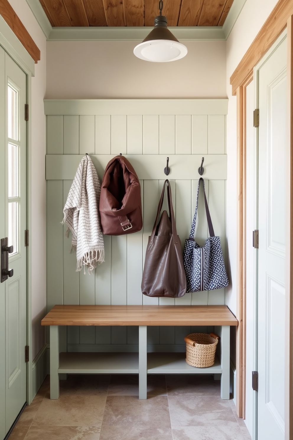 A charming mudroom features pale green hooks neatly arranged on the wall for coats and bags. The space is accented with natural wood elements and a durable tile floor that complements the soft color palette.