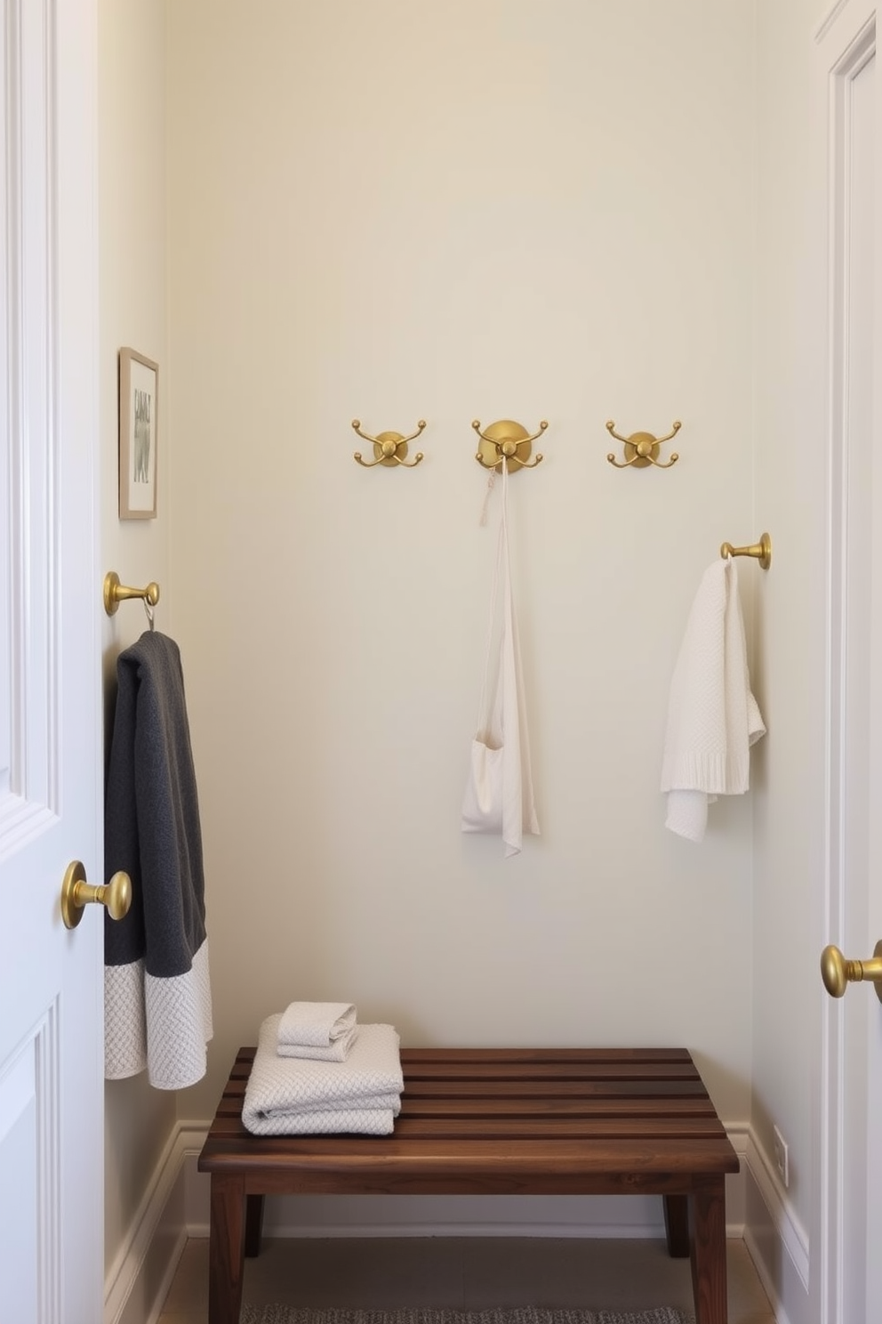 A stylish half bath featuring decorative hooks that add functional flair to the space. The walls are painted in a soft pastel color, complementing the elegant fixtures and accessories. The decorative hooks are made of brushed brass, providing a modern touch while serving as convenient storage for towels and accessories. A small wooden bench is placed beneath the hooks, enhancing the room's functionality and comfort.