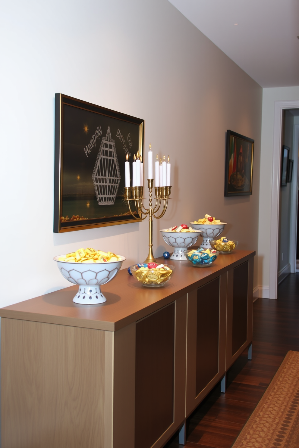 Decorative bowls filled with gelt and dreidels are artfully arranged on a long console table in the hallway. The walls are adorned with festive Hanukkah-themed artwork, and soft lighting creates a warm, inviting atmosphere.