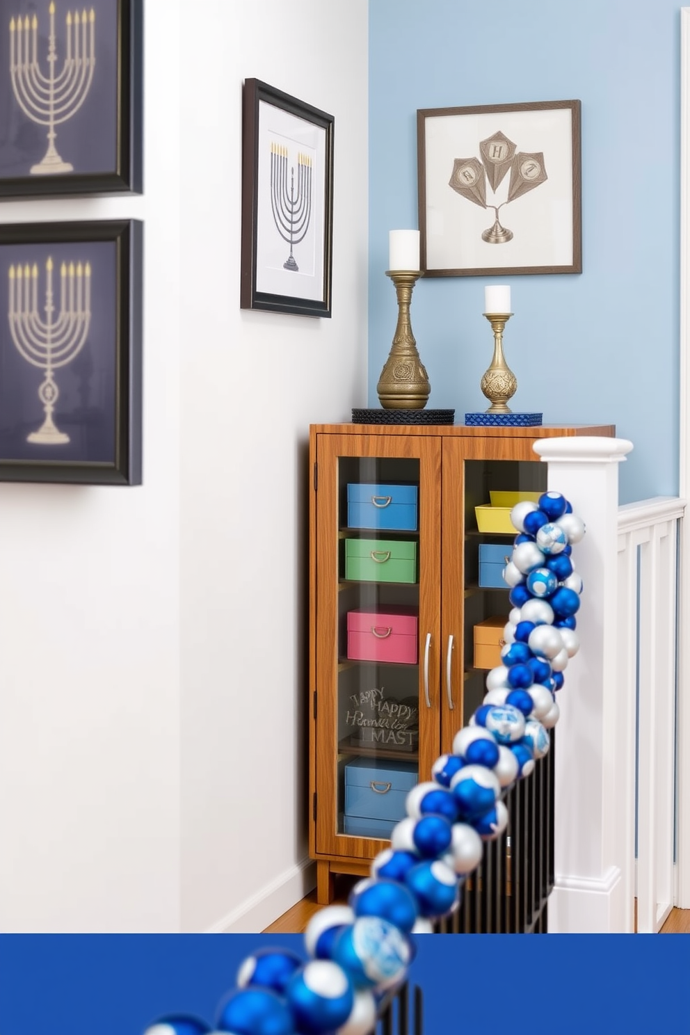 Stylish storage for Hanukkah supplies includes a sleek wooden cabinet with glass doors showcasing decorative boxes in vibrant colors. The cabinet is placed against a soft blue wall, adding a festive touch to the hallway. Hallway Hanukkah decorating ideas feature a garland of blue and silver ornaments draped along the banister. On the walls, framed artwork depicting menorahs and dreidels creates a warm and inviting atmosphere.