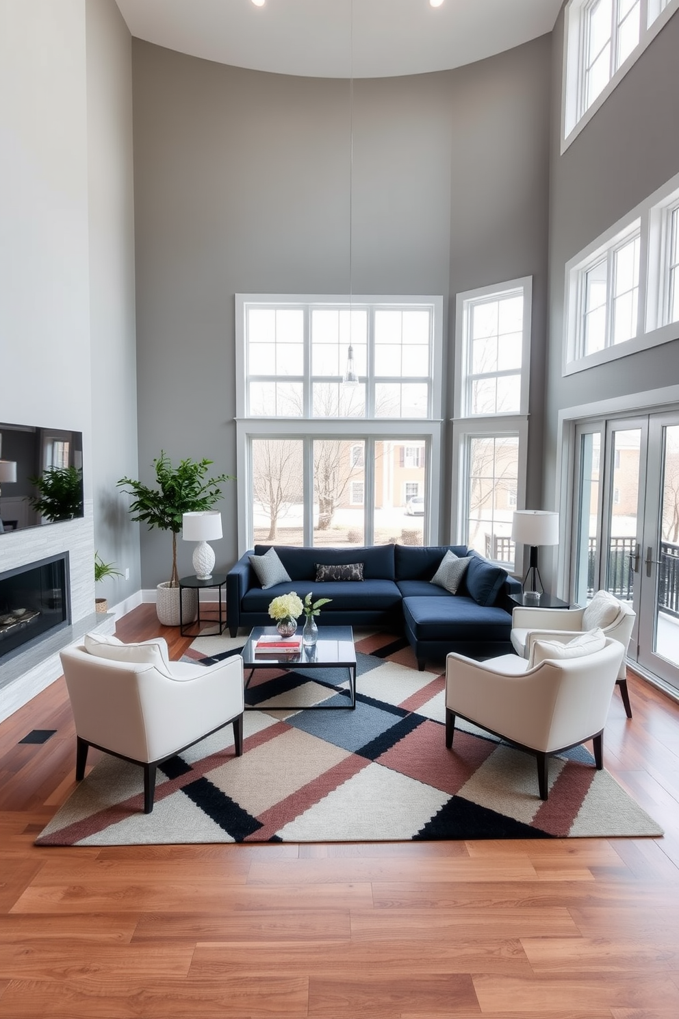 A high ceiling living room with expansive windows that allow natural light to flood the space. The walls are painted in a soft gray, creating a serene backdrop for the elegant furnishings. A plush sectional sofa in a deep navy blue anchors the room, complemented by a set of modern armchairs in a light cream fabric. A dramatic area rug with bold geometric patterns in contrasting colors adds visual interest and warmth to the hardwood floor.