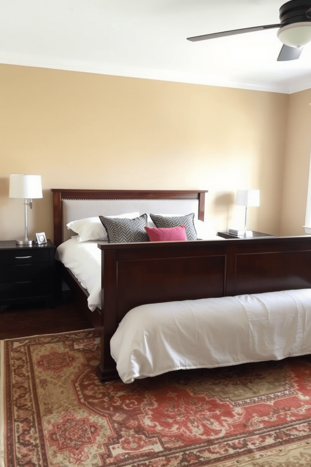 A cozy in-law bedroom that blends modern and traditional elements. The room features a classic wooden bed frame with an upholstered headboard, complemented by contemporary nightstands with sleek metal accents. The walls are painted in a warm beige tone, creating a welcoming atmosphere. A vintage area rug lies beneath the bed, adding texture and warmth to the space.