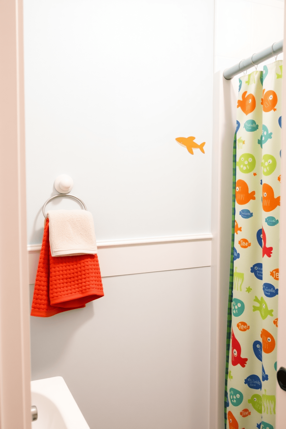 A playful kids bathroom featuring a wall-mounted drying rack for towels. The space is bright and colorful, with whimsical wall decals of sea creatures and a cheerful shower curtain in vibrant patterns.