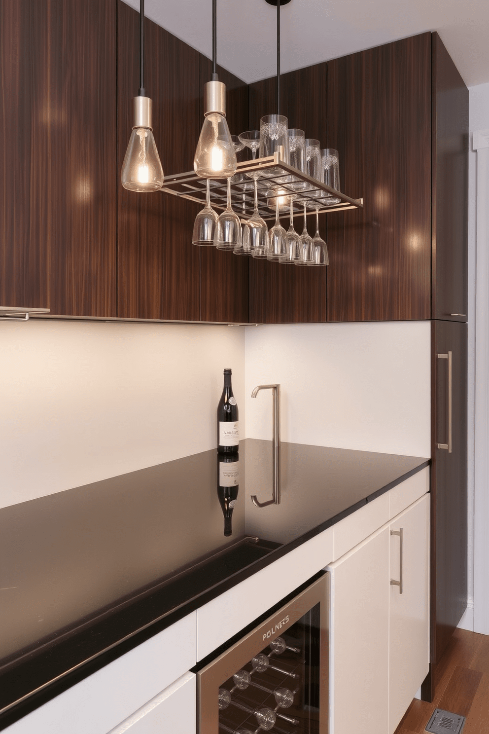 A sleek modern cocktail station features a polished black countertop with a built-in wine cooler and a stylish glass rack overhead. The cabinetry is a mix of matte white and dark wood, providing a contemporary contrast, while pendant lights hang above to illuminate the space.