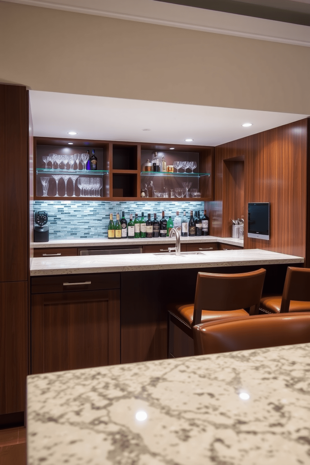 A sleek wet bar area features a polished granite countertop with a stylish backsplash made of glass tiles. Underneath, there are custom cabinetry and open shelving showcasing elegant glassware and premium spirits. The bar stools are upholstered in rich leather, complementing the warm wood tones of the cabinetry. Ambient lighting illuminates the space, creating an inviting atmosphere for entertaining guests.