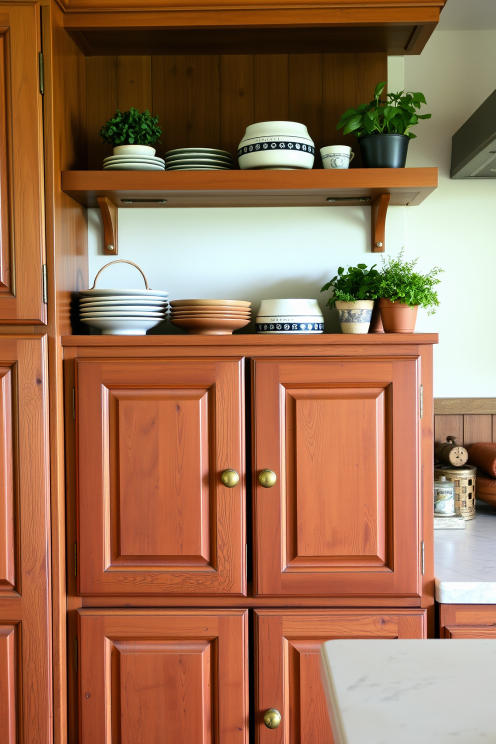 Rustic wooden cabinets with a distressed finish create a warm and inviting atmosphere in the kitchen. The cabinets feature intricate carvings and are complemented by vintage-style brass handles. Open shelving above the cabinets showcases rustic dishware and potted herbs. The overall color palette includes earthy tones that enhance the natural wood grain.