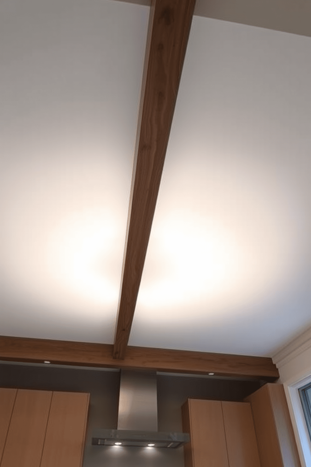 A stunning kitchen ceiling features a color gradient that transitions smoothly from a soft blue at the edges to a warm white in the center. This design creates a visually interesting focal point that enhances the overall ambiance of the space. The ceiling incorporates recessed lighting that highlights the gradient effect, providing both function and aesthetic appeal. Sleek wooden beams run parallel across the ceiling, adding a touch of warmth and texture to the modern kitchen design.