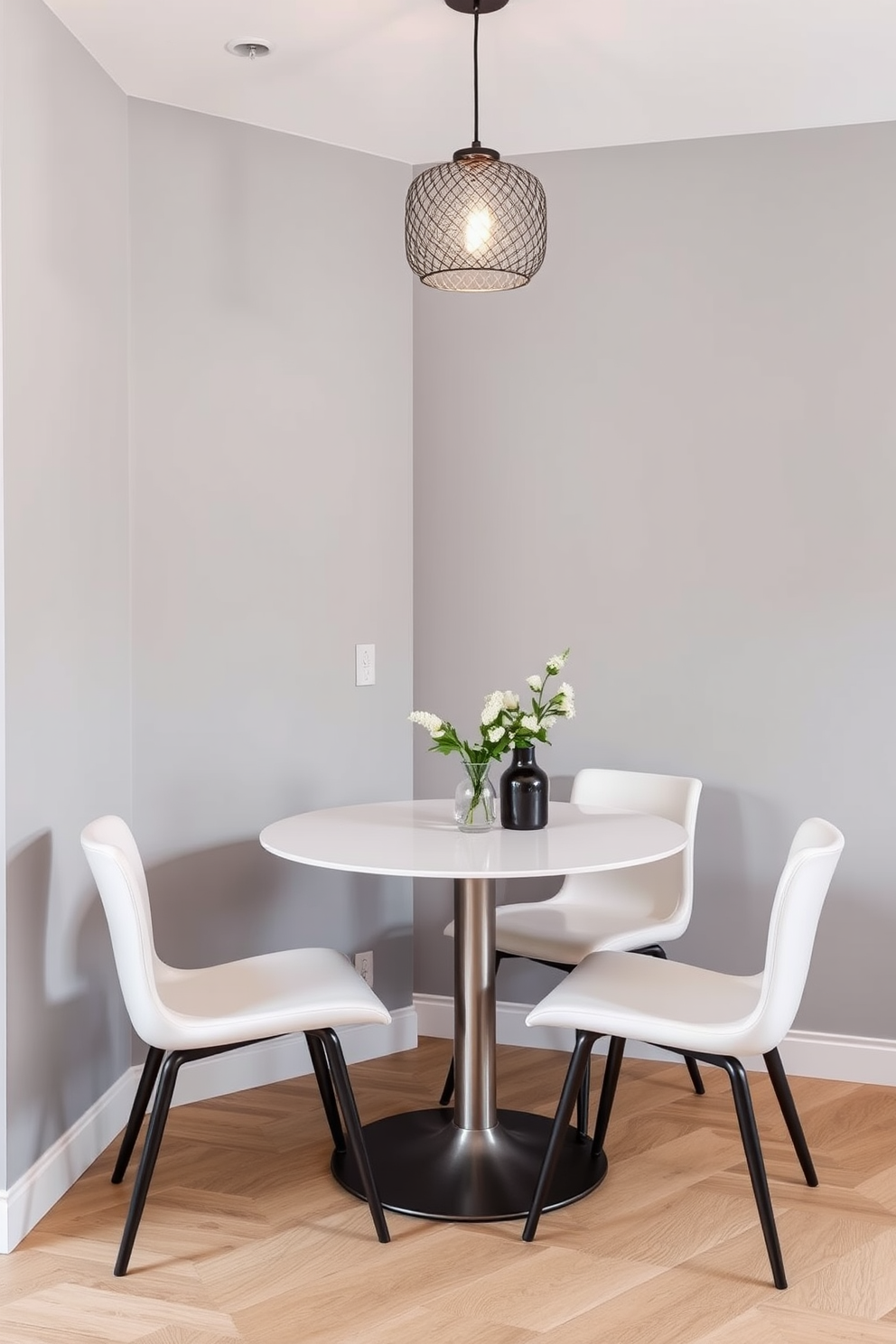 A compact dining table is set against a wall with a sleek design that maximizes space. Surrounding the table are stylish chairs that complement the modern aesthetic of the kitchen dining room. The walls are painted in a soft gray tone, creating a cozy atmosphere. A decorative pendant light hangs above the table, adding warmth and elegance to the dining experience.